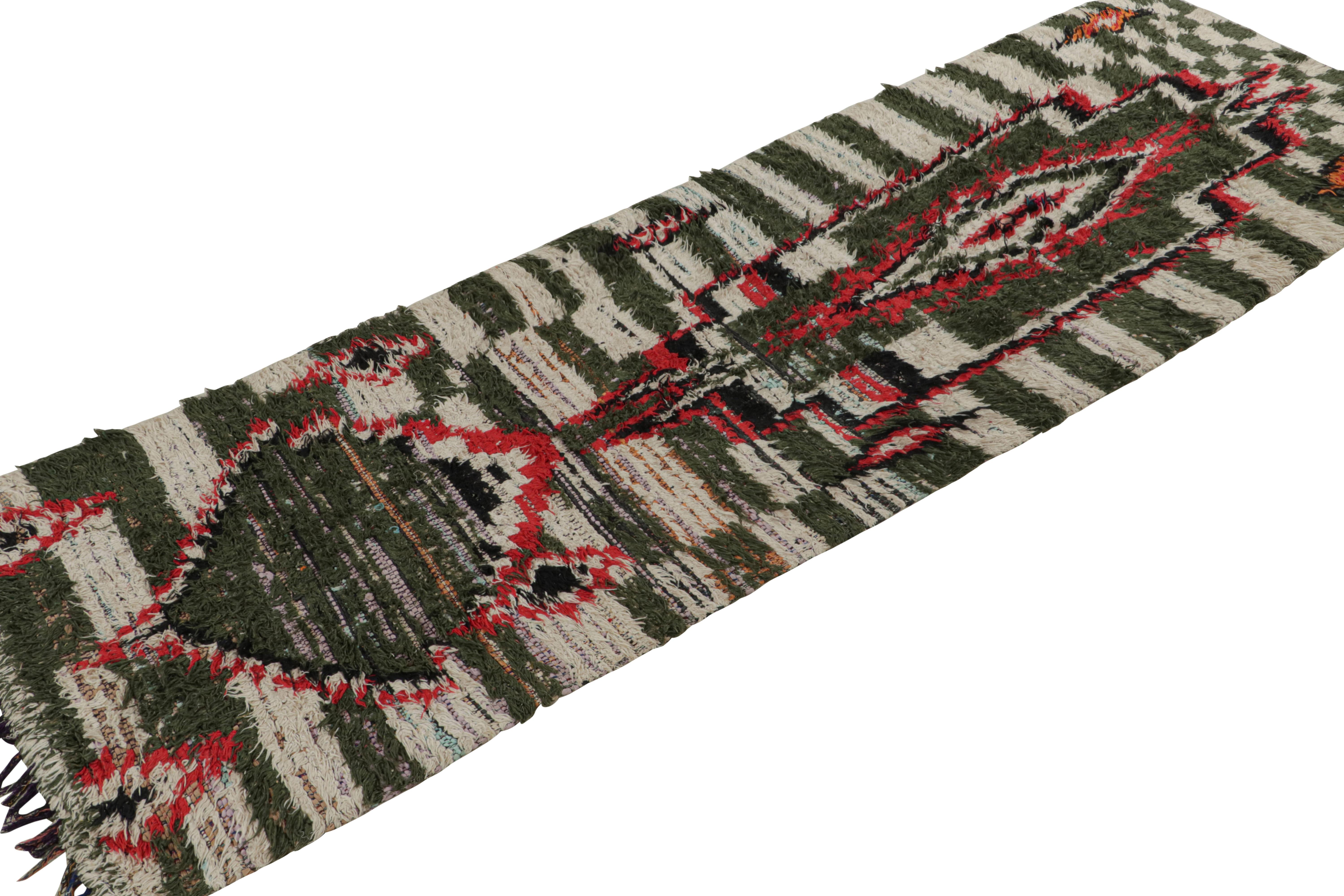 Hand-knotted in cotton and fabric circa 1950-1960, this vintage 3x9 Moroccan runner and Boucherouite rug is believed to hail from the Azilal tribe. 

On the Design: 

This runner enjoys green-white tribal patterns with red and black juxtapositions.