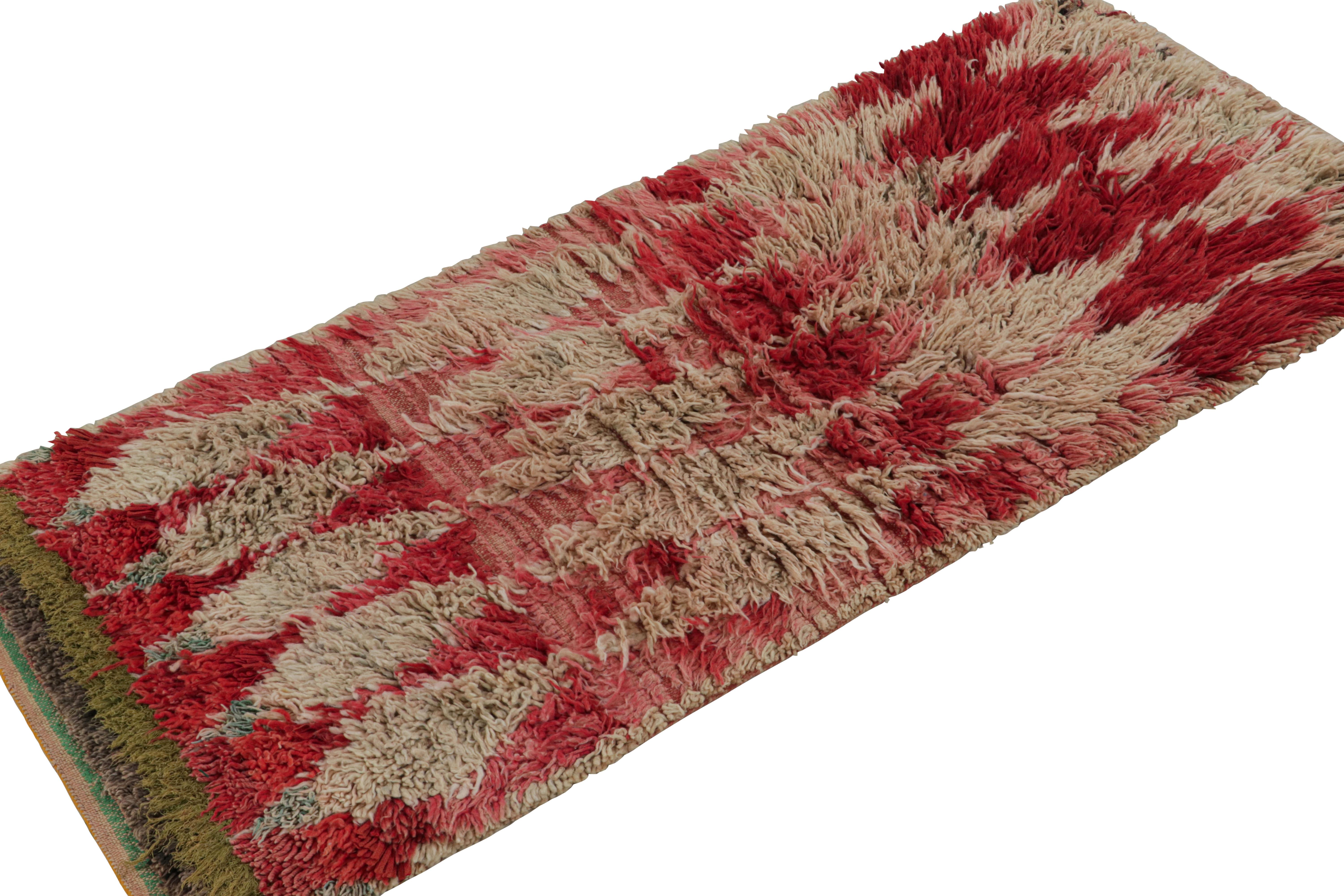 Hand-knotted in wool, circa 1950-1960, this 2x6 vintage Moroccan runner rug is believed to hail from the Azilal tribe. 

On the Design: 

This piece enjoys a lush high pile with taupe field and primitivist Berber pink and red geometric lozenges