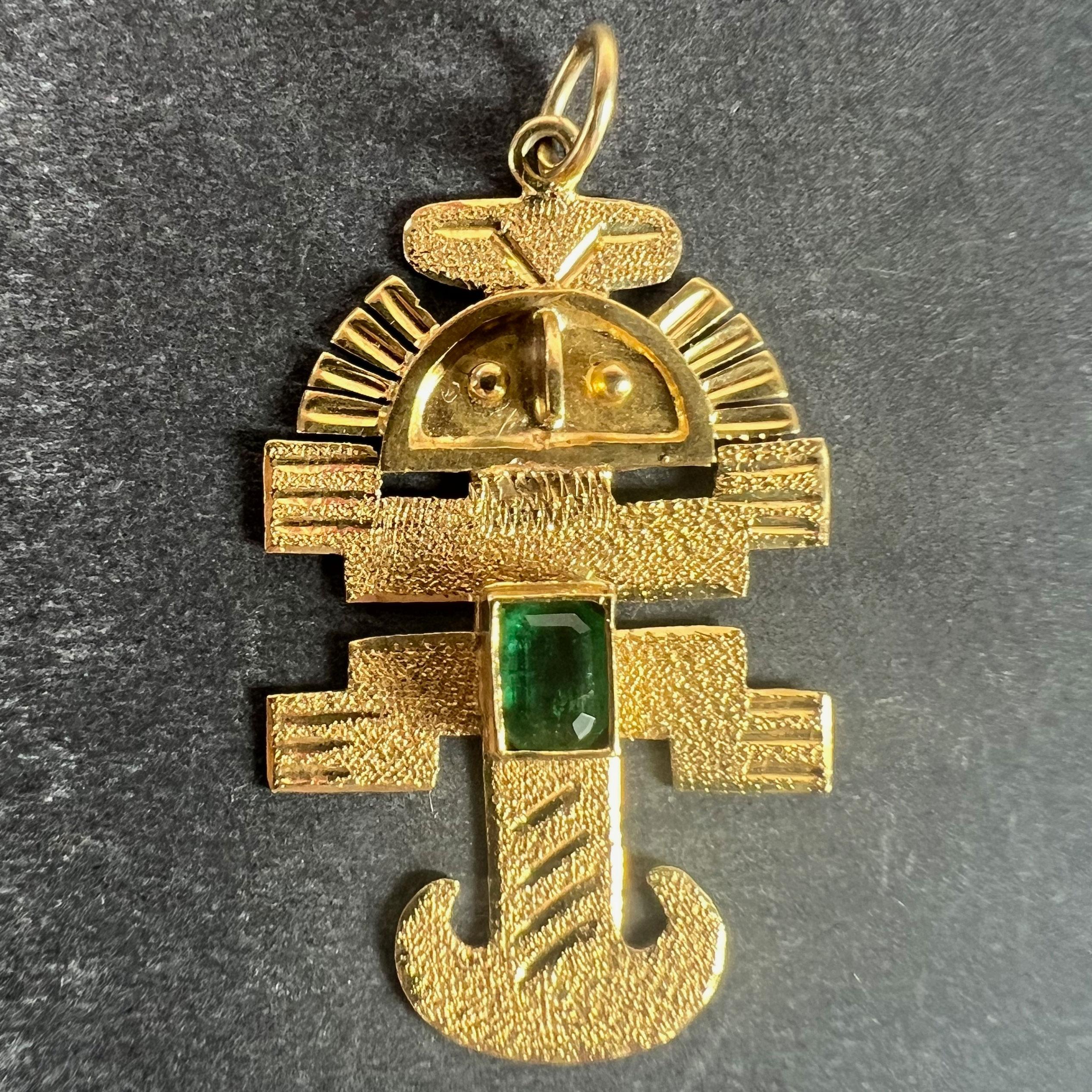 A vintage 18 karat (18K) yellow gold charm pendant designed as an Aztec or Inca god or icon set with an emerald cut emerald with an estimated weight of 0.27 carats. Unmarked but tested for 18 karat gold.

Dimensions: 3.1 x 1.9 x 0.25 cm (not