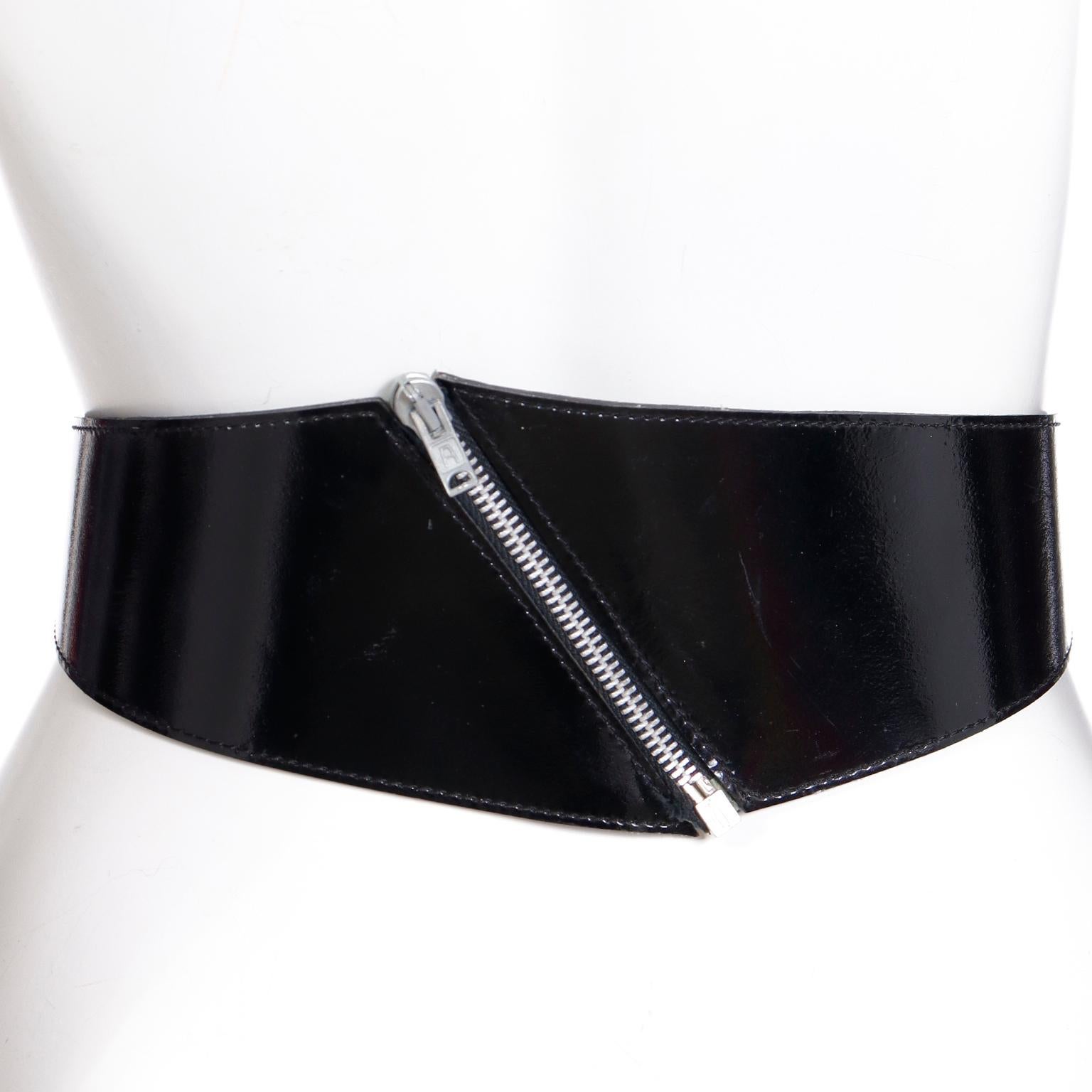 This iconic vintage Azzedine Alaia Paris wide black patent leather belt features a silver tone diagonal zipper at the center front. The beautiful belt is marked Vacher Pour Alaia and was Made In France in the late 1980's. You can wear this belt with