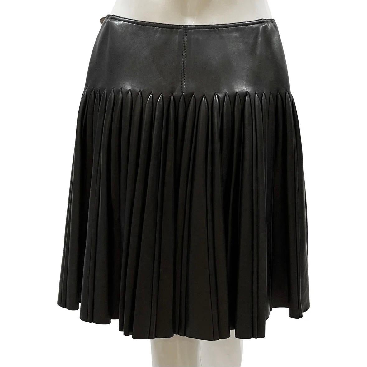 Pleated vintage mini skirt by Azzedine Alaia
Made in France 
Black leather   
Pleated around back and sides with smooth front panel
Double buckle side wrap closure (internal hook closure)
Waist buckles are adjustable
Bronze-tone hardware  
100%
