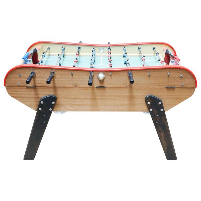 Table football style of Bonzini from France, circa 1990.

In original condition, with minor wear consistent with age and use, preserving a beautiful patina.

Material:
Metal
Wood

Dimensions:
D 110 cm x W 168 cm x H 104 cm.