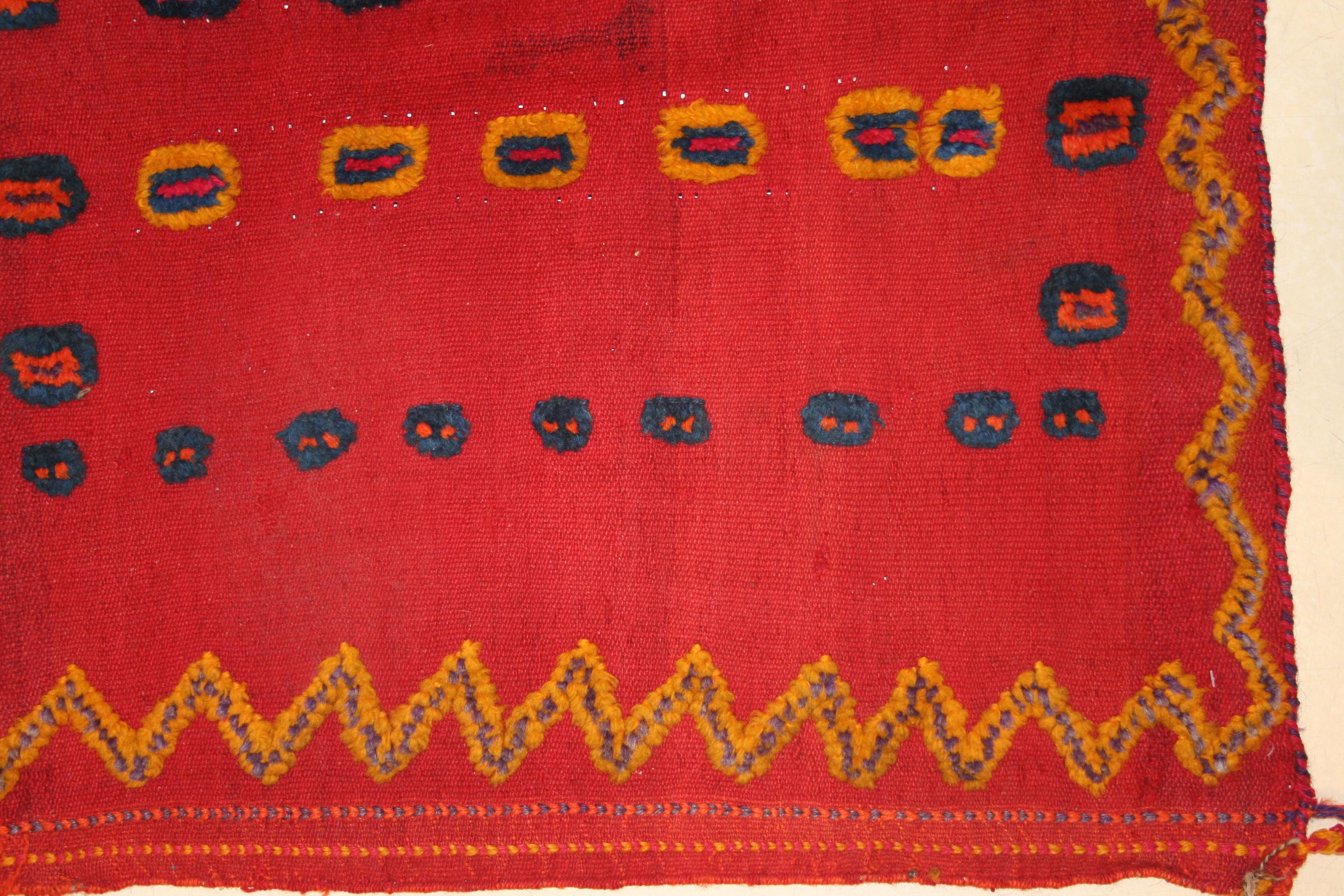 Ein bezauberndes Stammesgeflecht mit einem flach gewebten roten Hintergrund und einem Muster aus polychromen konzentrischen Kreisen, die im Flor verknotet sind und einen Reliefeffekt erzeugen. Sie wurde innerhalb des Stammes als Babywiege verwendet