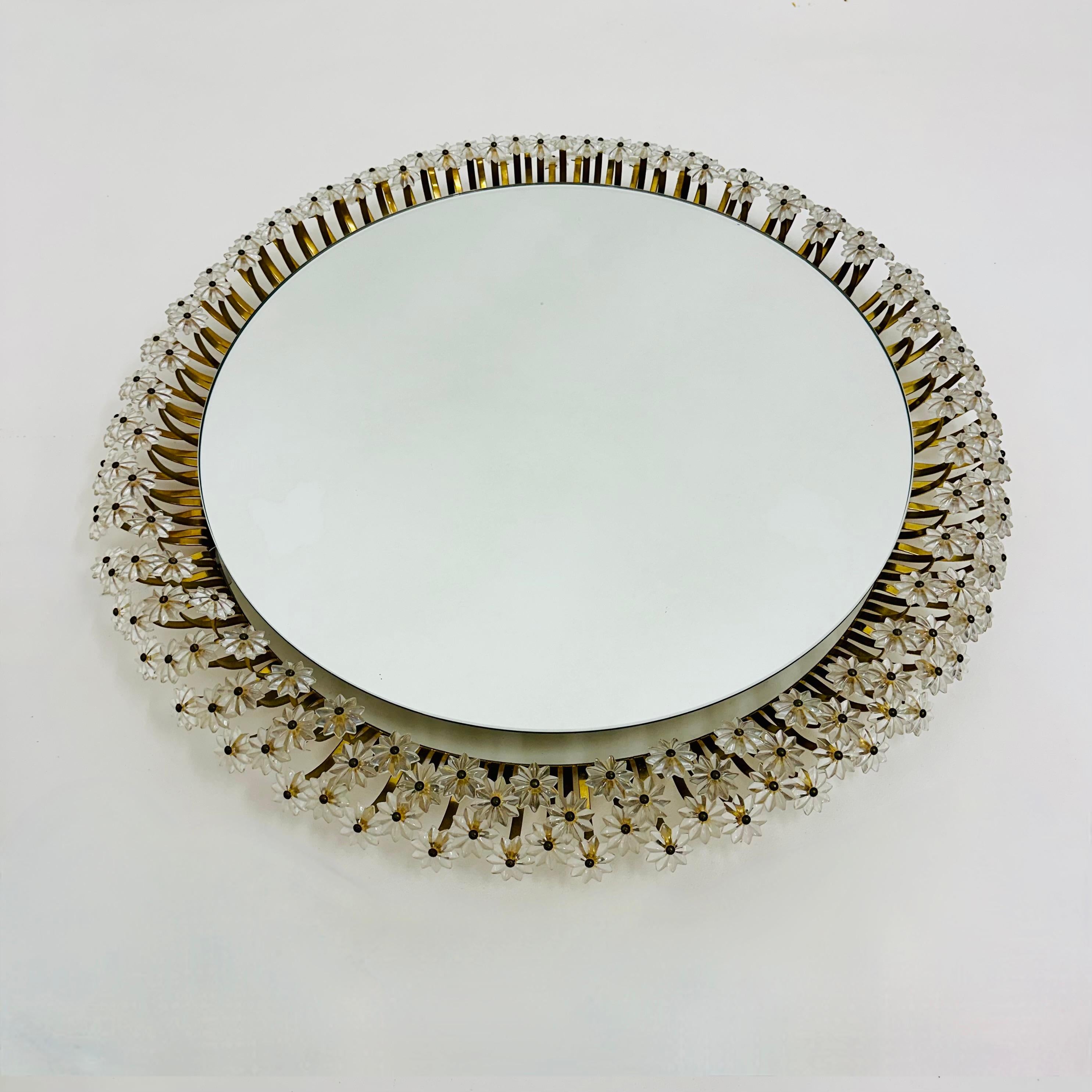 Élégant miroir rond floral éclairé, conçu par Eleg Stejnar. Stejnar était l'un des plus importants designers de lampes et d'éclairages ayant travaillé pour le fabricant viennois de lampes Rupert Nikoll. Ce miroir lumineux comporte 3 rangées de
