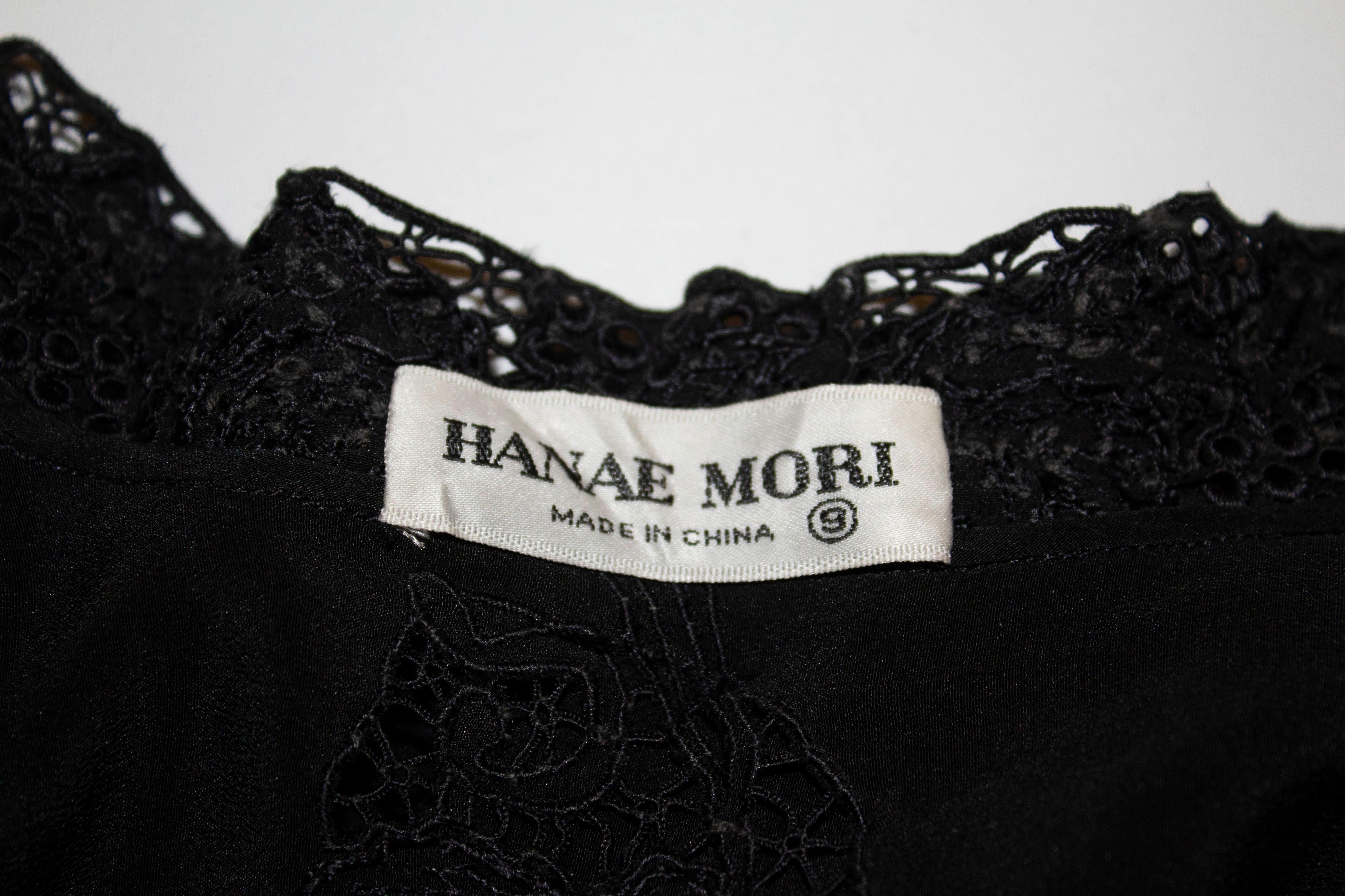 A chic vintage black silk blouse with lace detail by Hanae Mori. The blouse has  stand up collar with lace front and cuff detail. It has popper cuffs and silk covered buttons.
Measurements : Bust 35'', length 24''