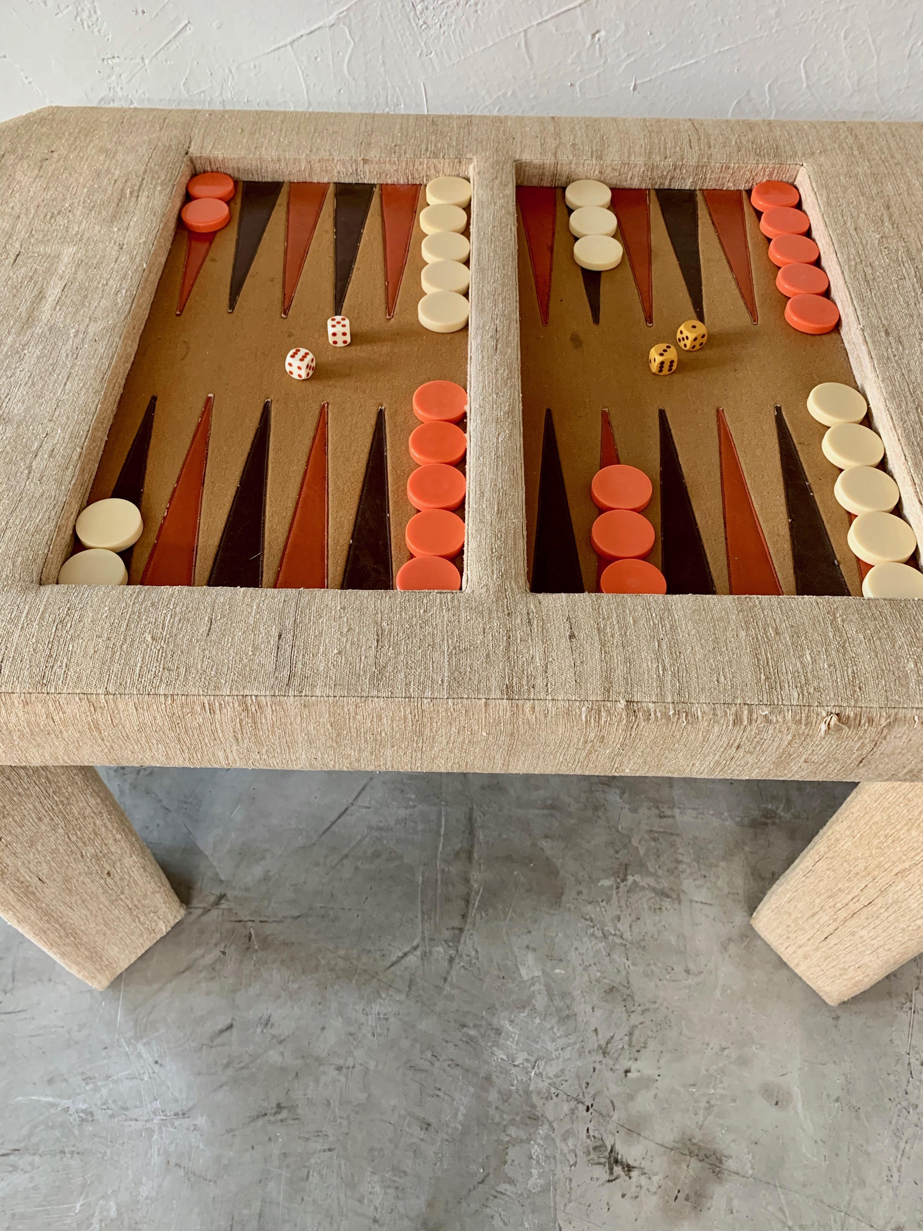 Vintage backgammon table in the style of Karl Springer. Fabric wrapped frame with felt game board and leather triangles. Oversized bakelite backgammon pieces included. Wear to fabric on corners, some wrinkles in fabric. Wear to felt game board.