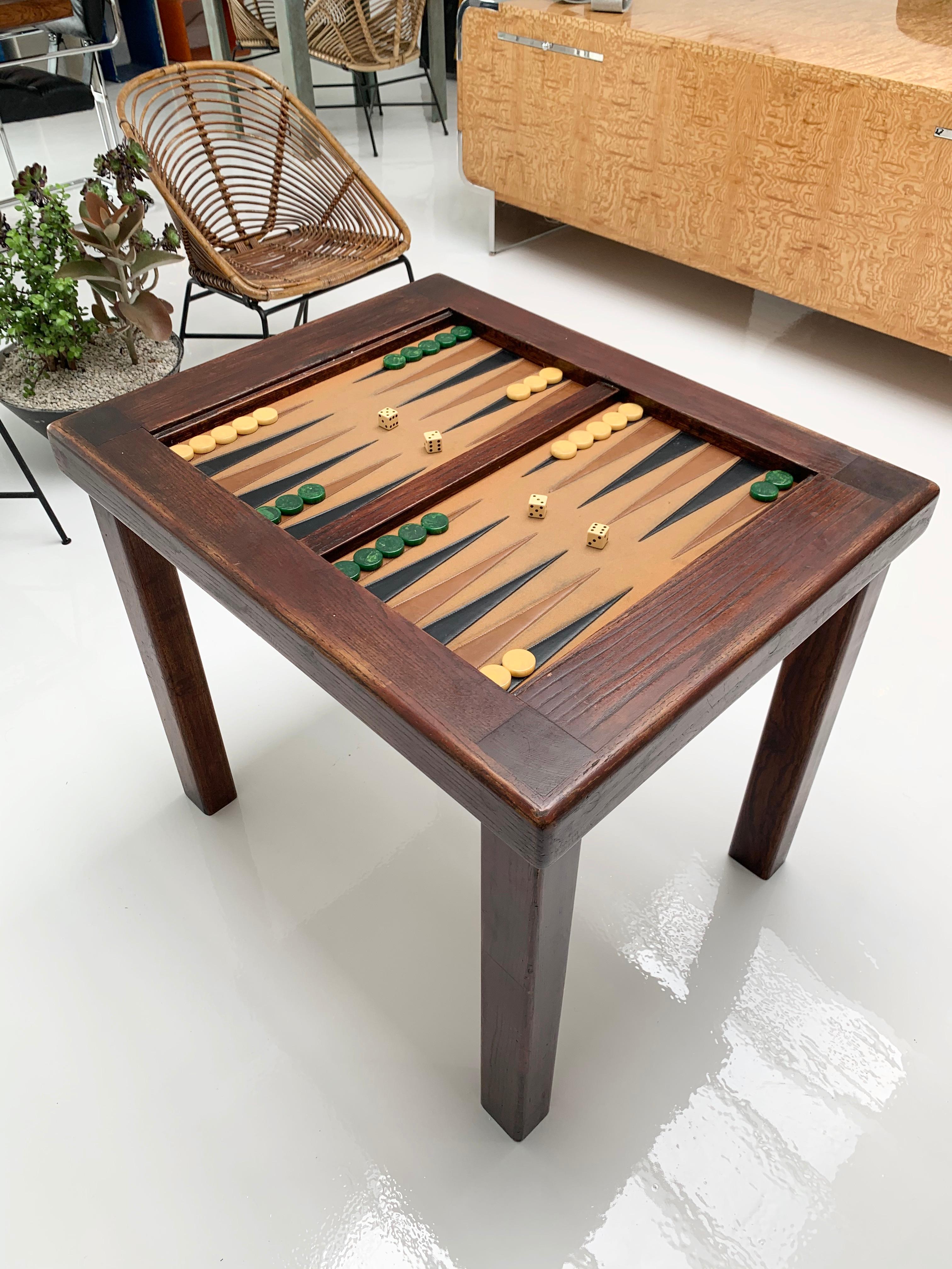 Classic wood backgammon table with removable glass top. Inside lays a felt backgammon board with leather triangles. Good vintage condition. Some light stains to felt. Set includes vintage Bakelite dice and vintage game pieces.