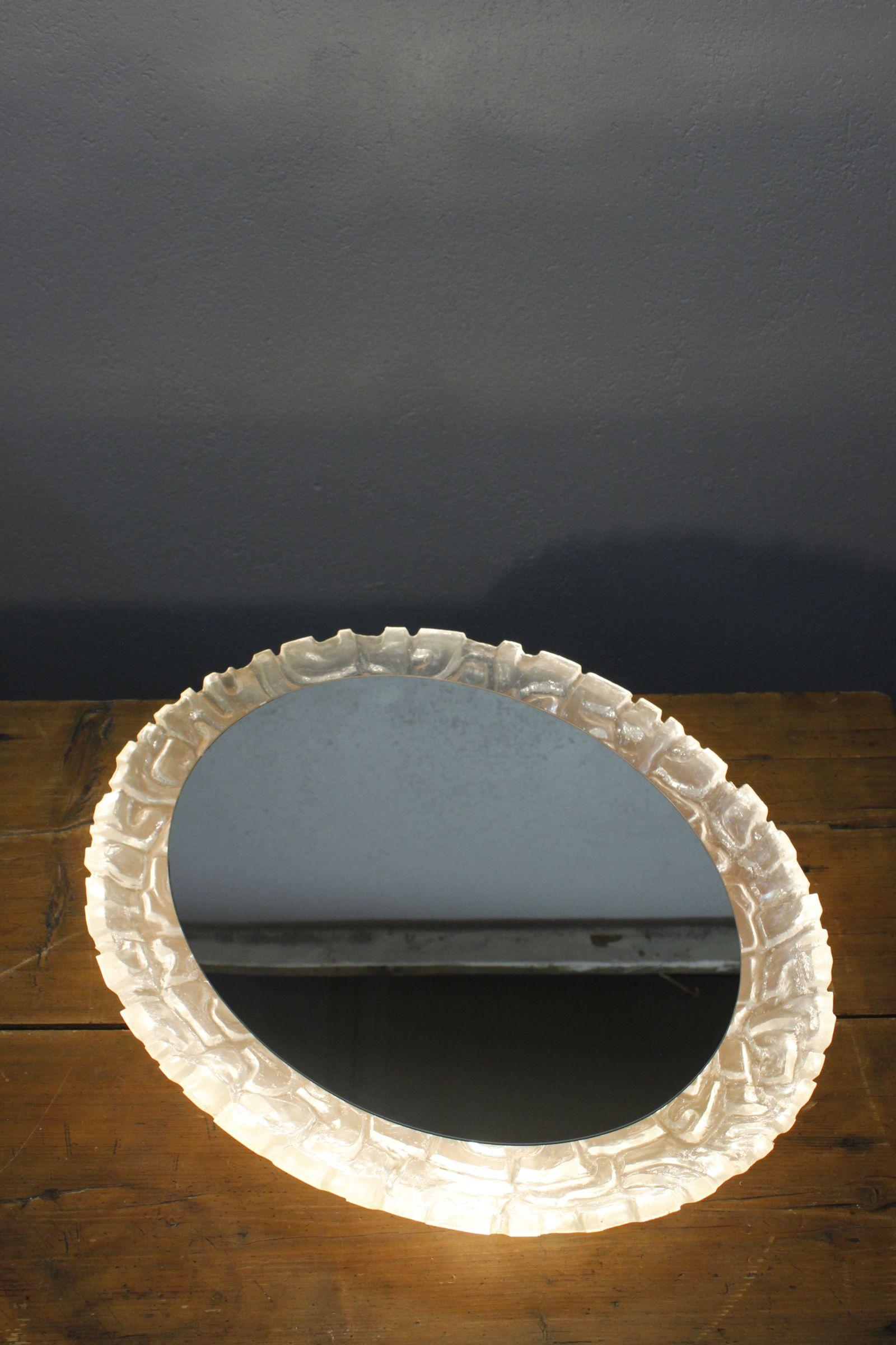 Magnifique miroir rétro-éclairé des années 70 avec cadre épais en résine transparente à effet givré, idéal pour la chambre ou la salle de bains. Une pièce lourde de qualité qui peut être suspendue en portrait ou en paysage, le miroir se glisse