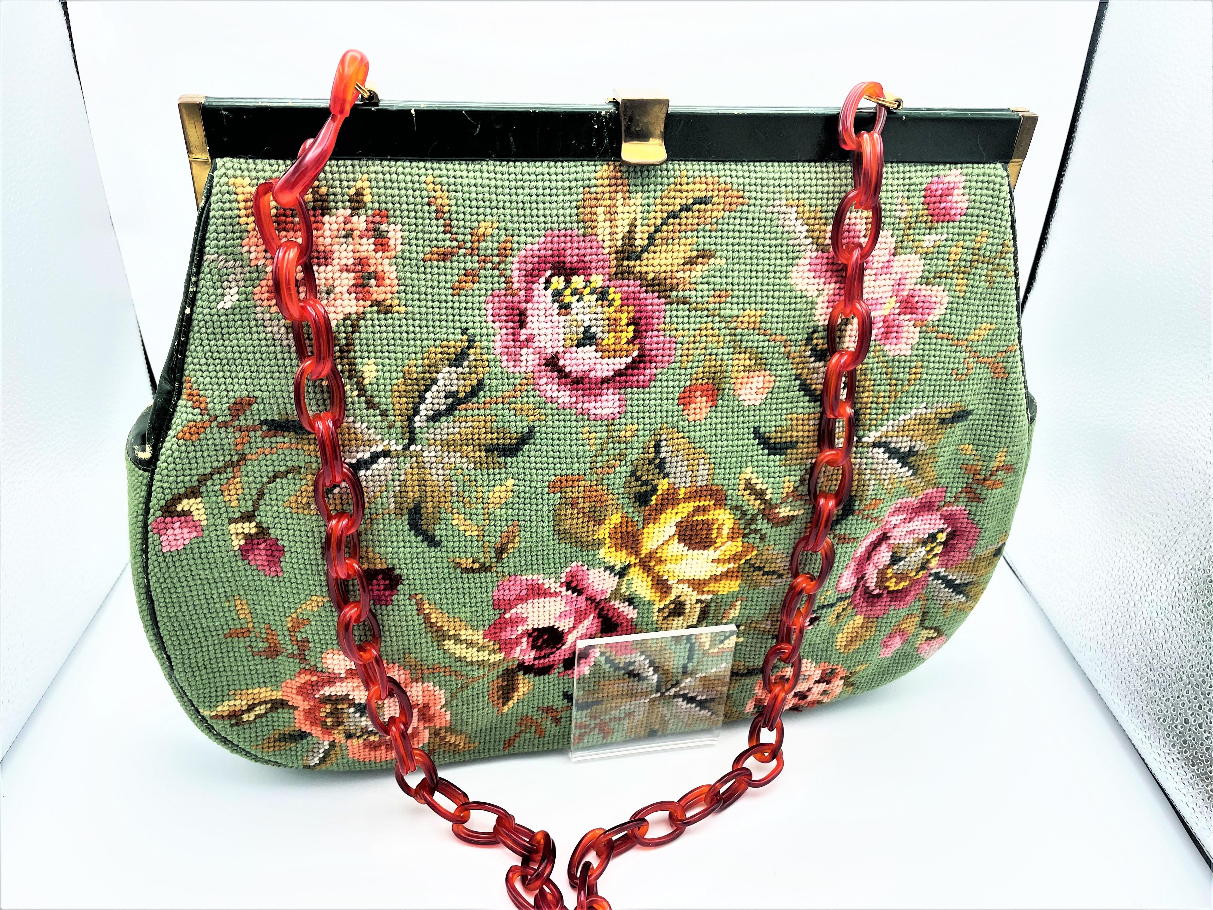 A hand embroidered bag all around. Colorful roses with buds and leaves on a light green background. Inside lined light leather with a zipper compartment and 3 other compartments. The upper opening is covered with green leather, green leather on the