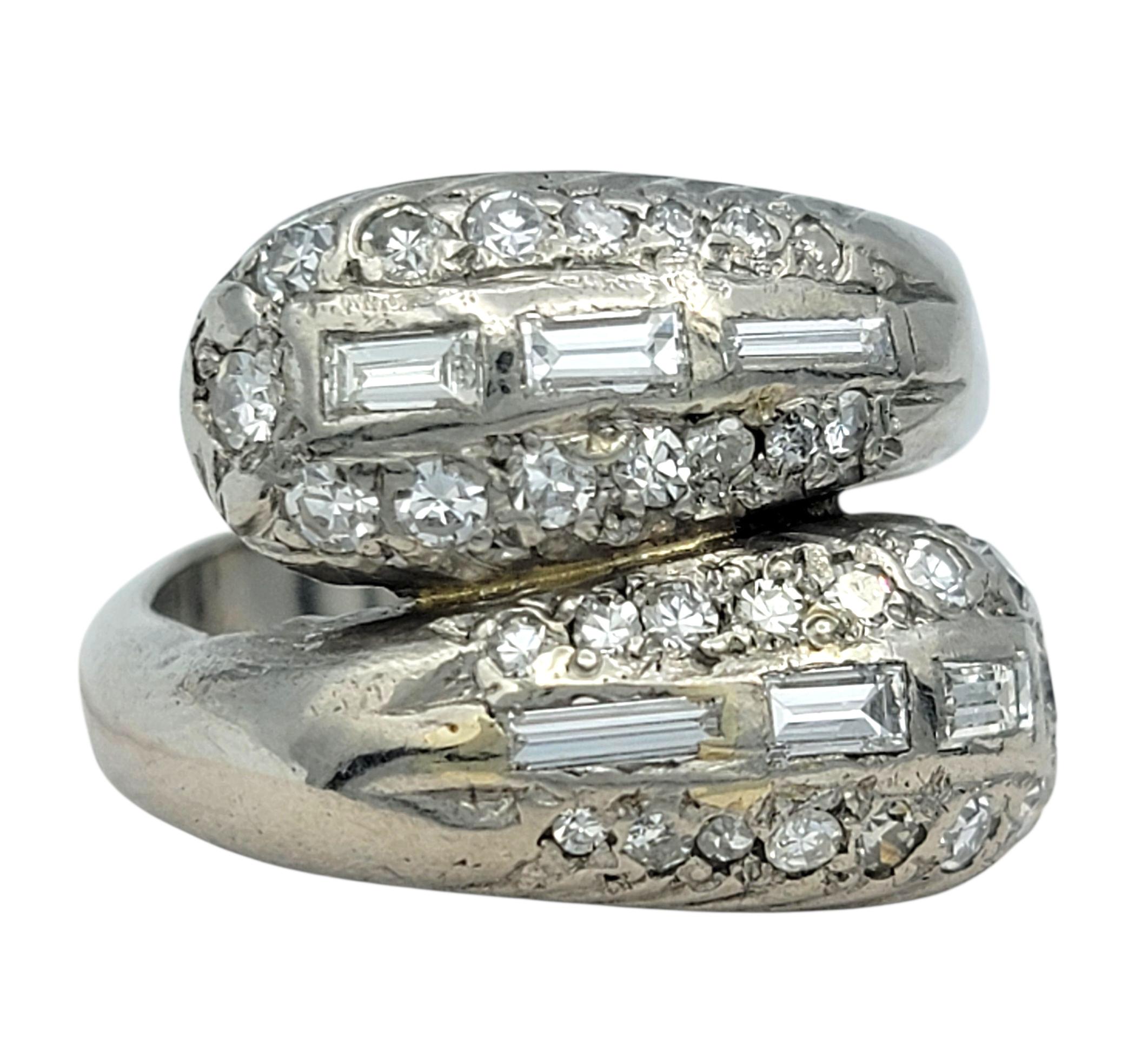 Questo elegante anello presenta una raffinata combinazione di diamanti a baguette e a taglio singolo disposti in un design geometrico di ispirazione vintage. Le pietre sono incastonate in file nitide che ne evidenziano la forma e la brillantezza,