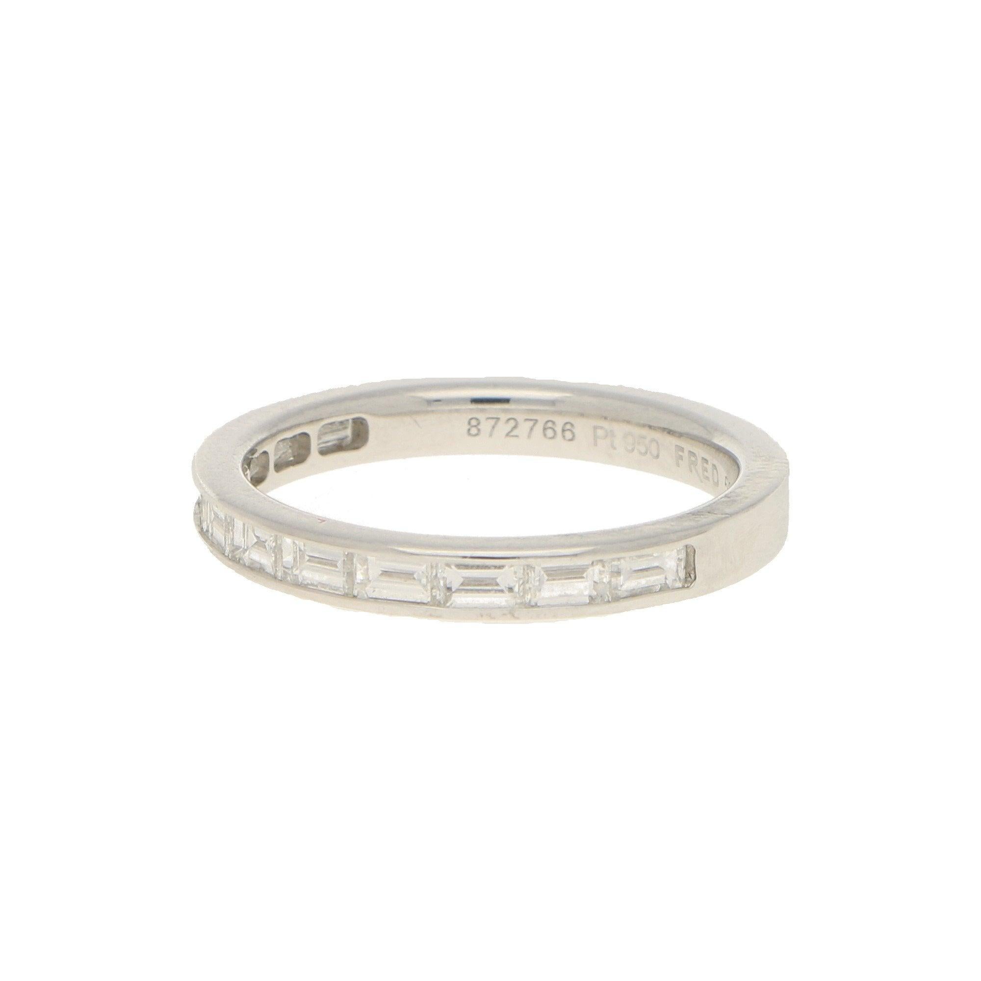 Diamonds approximately 0.55 carats in total, G colour, VS clarity.
A vintage Fred Paris baguette-cut diamond half-eternity band in platinum. 
The ring features eleven channel-set baguette-cut diamonds, to a solid flat court-shape 2.7mm wide ring. 