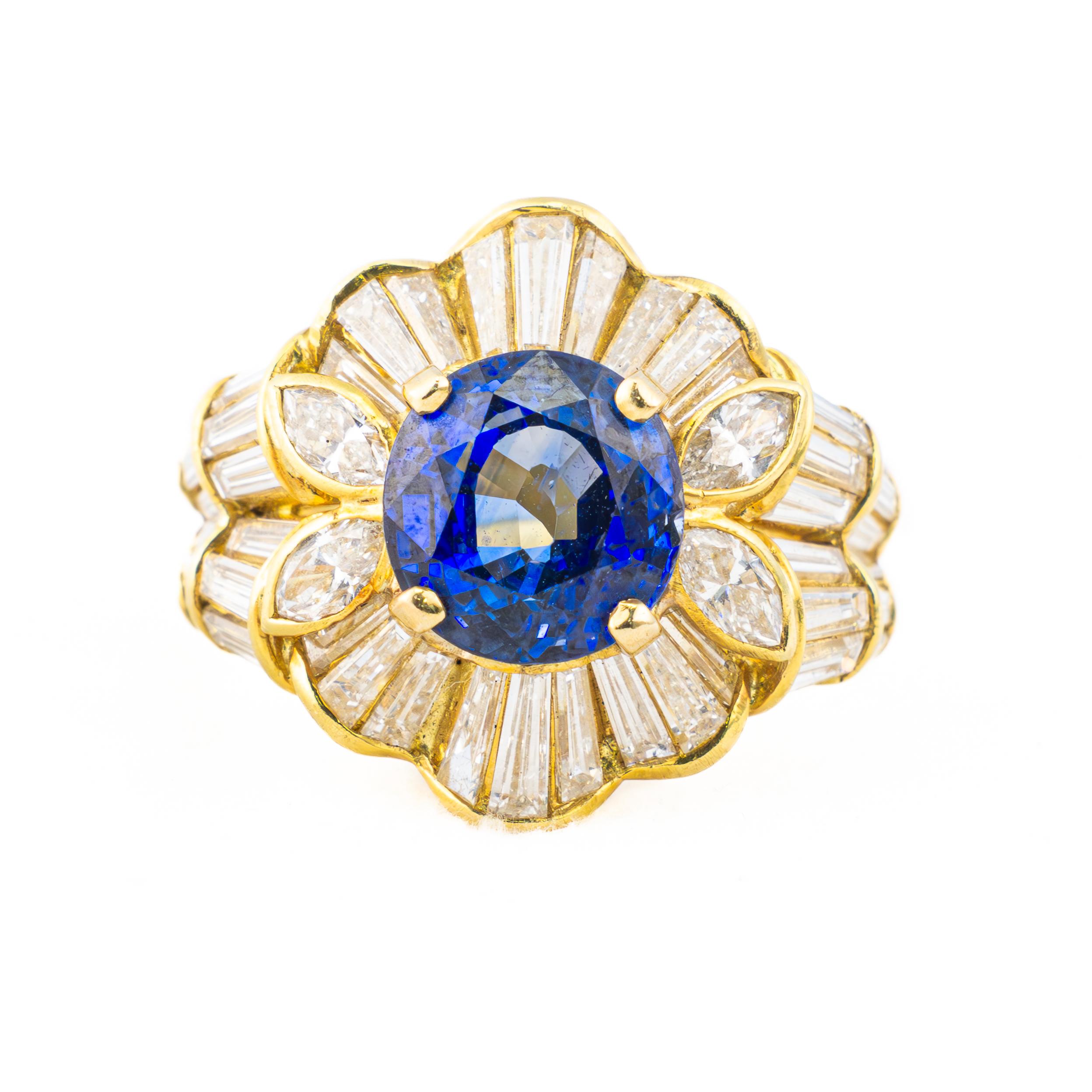 Vintage Sapphire and Diamond Baguette Cluster Ring

A striking vintage sapphire and diamond ring, masterfully crafted in luminous 18K yellow gold. The centerpiece is a captivating deep blue sapphire, embraced by an elaborate arrangement of dazzling