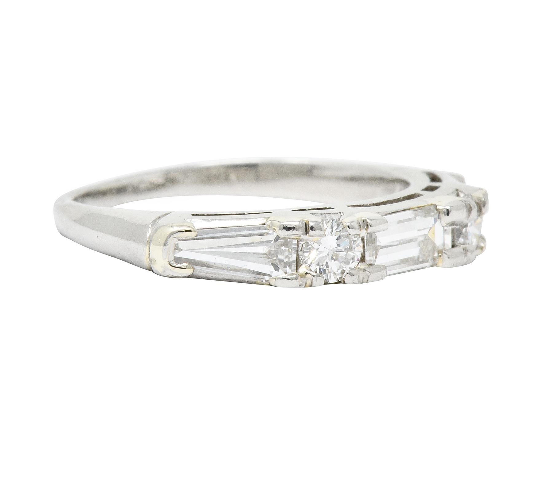 Band style ring set to front with diamonds weighing in total approximately 0.80 carat, G/H color with VS clarity

Centering a baguette cut diamond, flanked by two round brilliant cut diamonds, and completed by two outer tapered baguette cut
