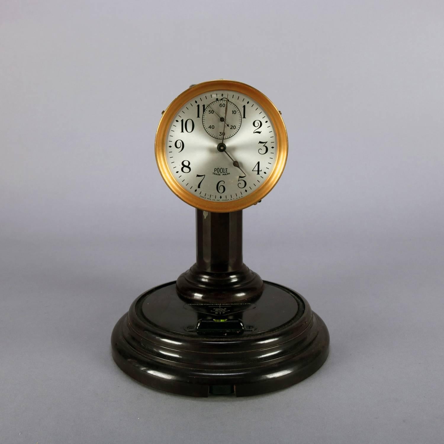 Poole Battery operated dome clock. Features 3.25 in. silvered dial with black Arabic hour numbers, Sub seconds dial, blued hands, brass bezel and signed on face “Poole Mfg. Co. Inc. Ithaca, NY, U.S.A.”; brass movement with pendulum running on