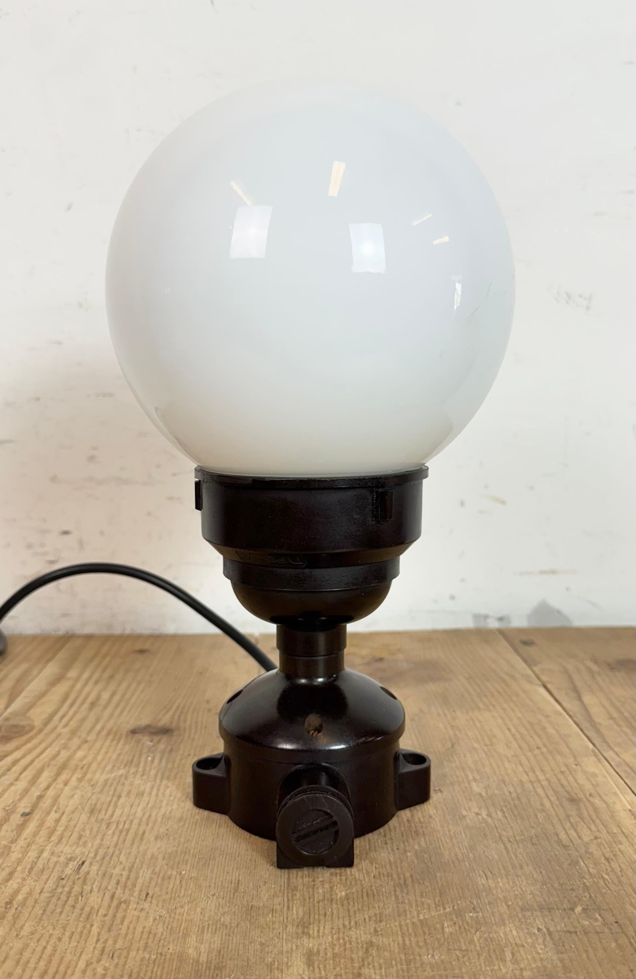 Plafoniera industriale d'epoca realizzata negli anni '60 nell'ex Cecoslovacchia. Presenta un attacco a soffitto in bachelite marrone e un coperchio in vetro lattiginoso. La presa richiede lampadine E27/E 26. Un nuovo cavo. Il peso della lampada è di