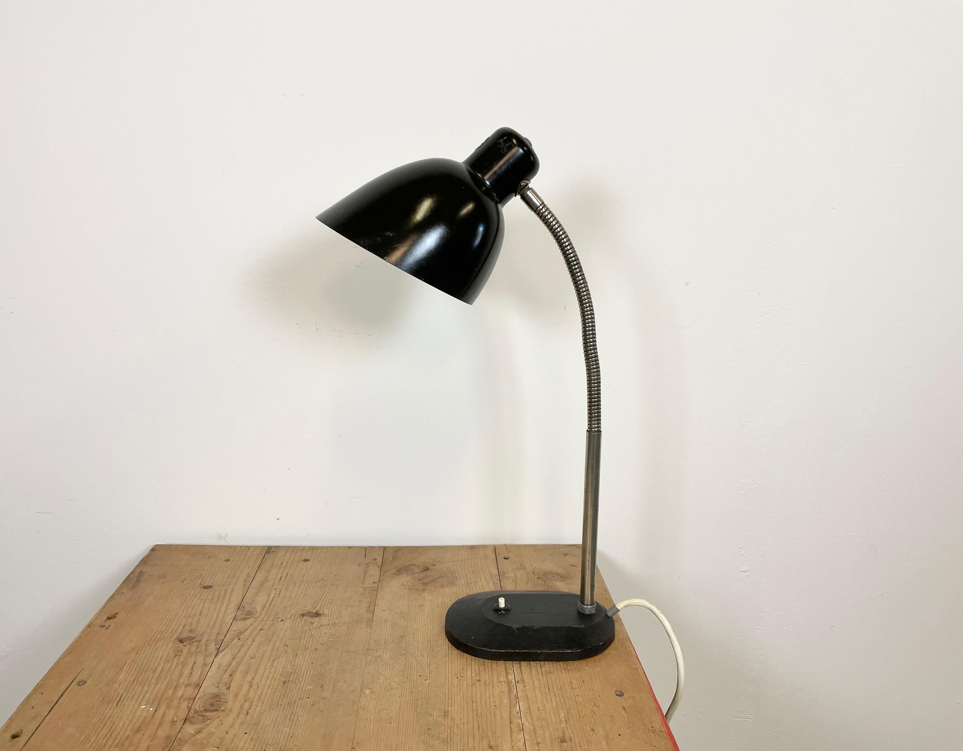 Lampe de bureau vintage allemande en bakélite de style Bauhaus, avec un abat-jour en bakélite noire, un col de cygne chromé et une base en fonte avec interrupteur d'origine. La douille est prévue pour des ampoules E 27. Le diamètre de l'abat-jour