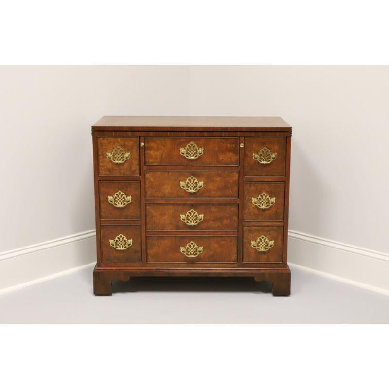A serving chest in Walnut and Burl Walnut by Baker Furniture. Made in the USA in the late 20th Century. Features a flip top for serving as well as 8 dovetail drawers for storage. Chippendale style with bracket feet and brass hardware.

Measures: 