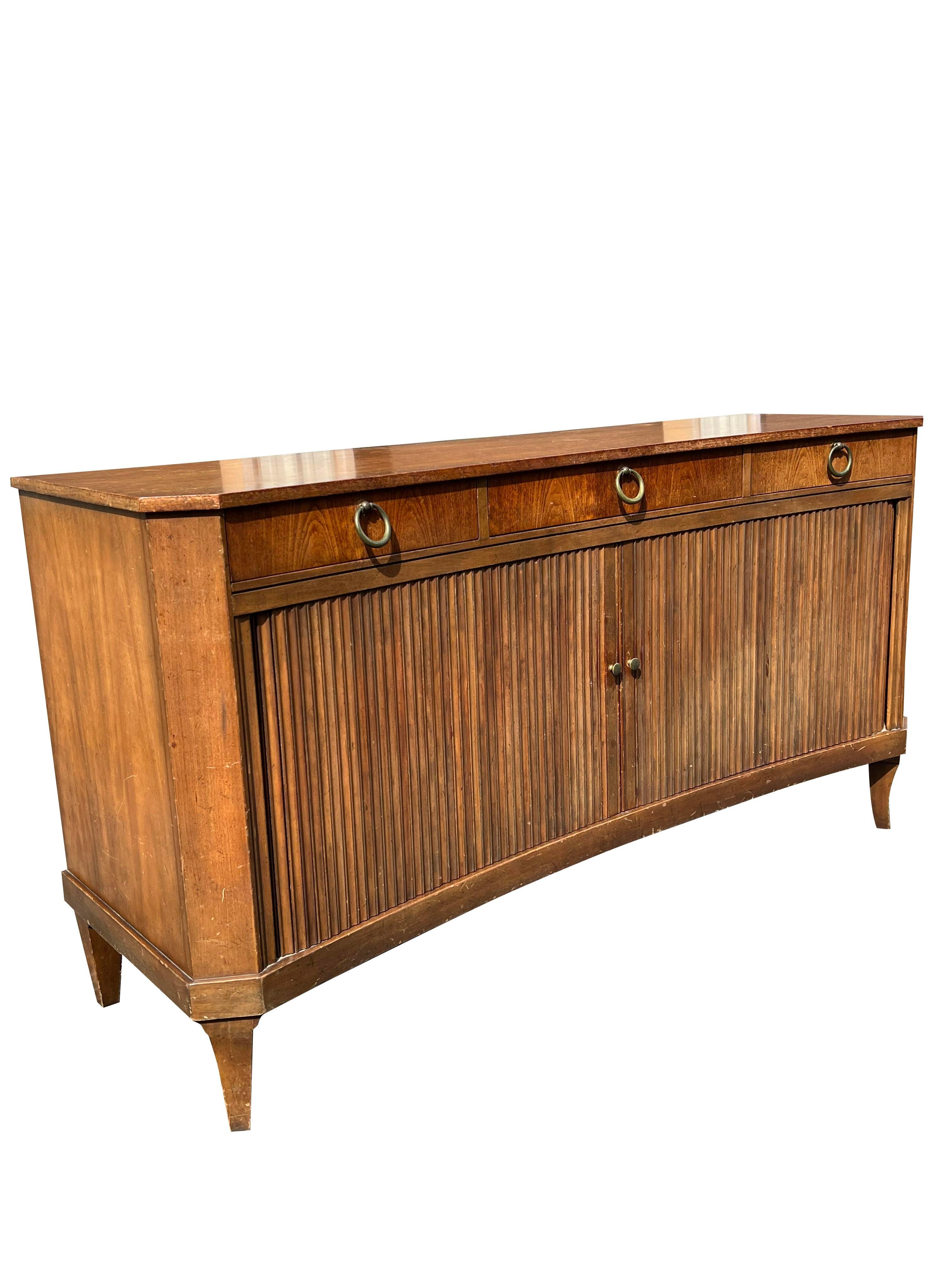 A Timeless Piece: Vintage Baker Tambour Credenza.

This elegant vintage tambour credenza from Baker Furniture Company is a stunning example of mid-century modern design. Its distinctive tambour doors, crafted from rich wood, offer ample storage