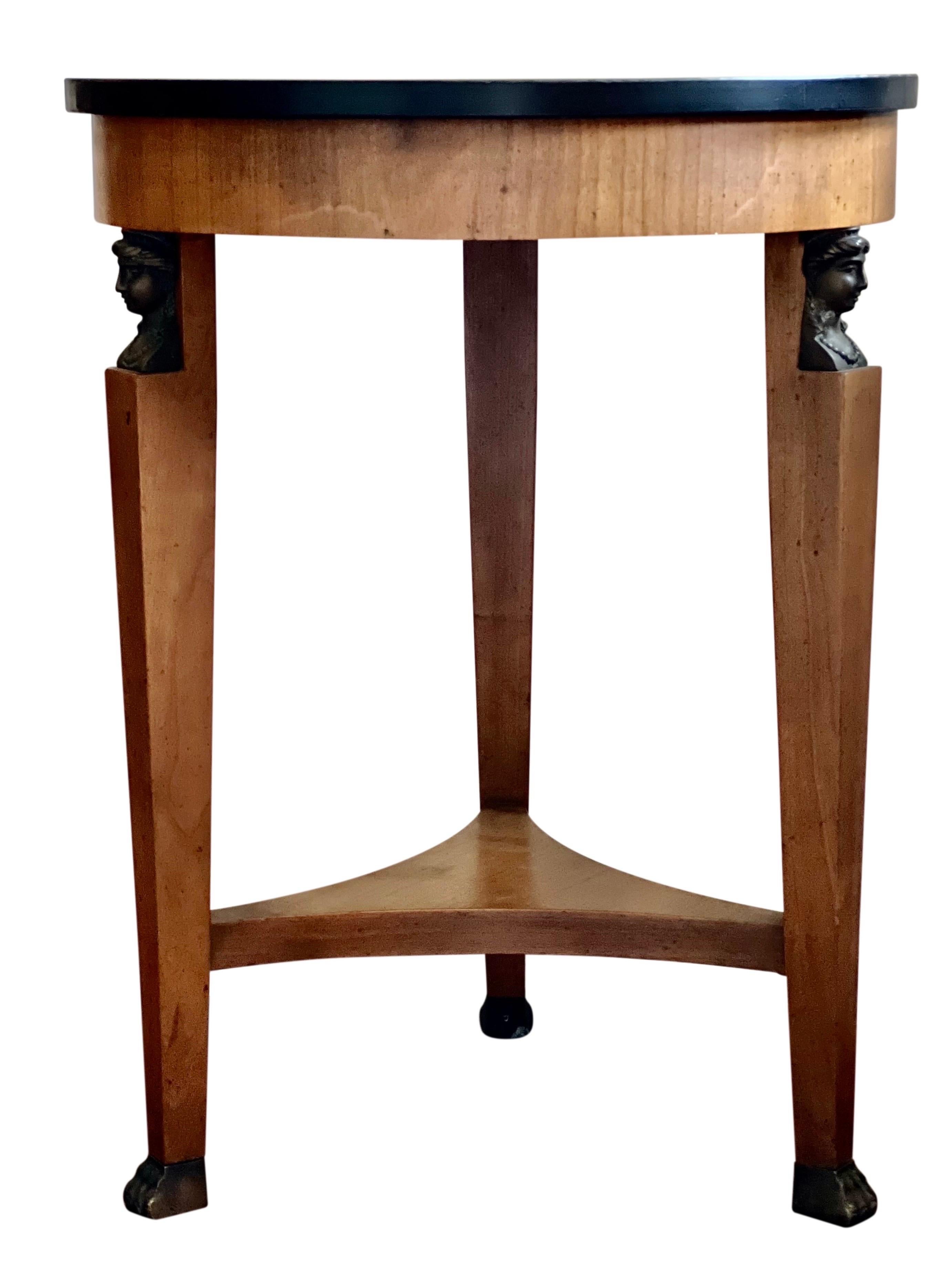 Vintage Baker French Empire style side table or gueridon, 1980's. This lovely table features an ebonized round top, bronze claw feet and bust accents. Both elegant and practical, a perfect petite side table useful almost anywhere in a room.