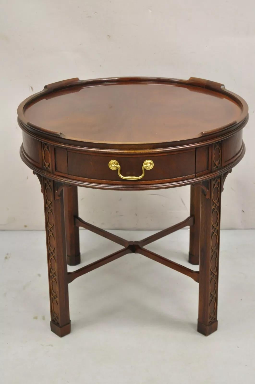 Vintage Baker Furniture Chinese Chippendale Mahagoni Laubsägearbeiten Runde Beistelltisch. Eine Schublade, geschnitzte Laubsägeecken und -beine, Messingbeschläge, Keilrahmensockel, bearbeitete Rückseite, Original Label. CIRCA Spätes 20. Jahrhundert.