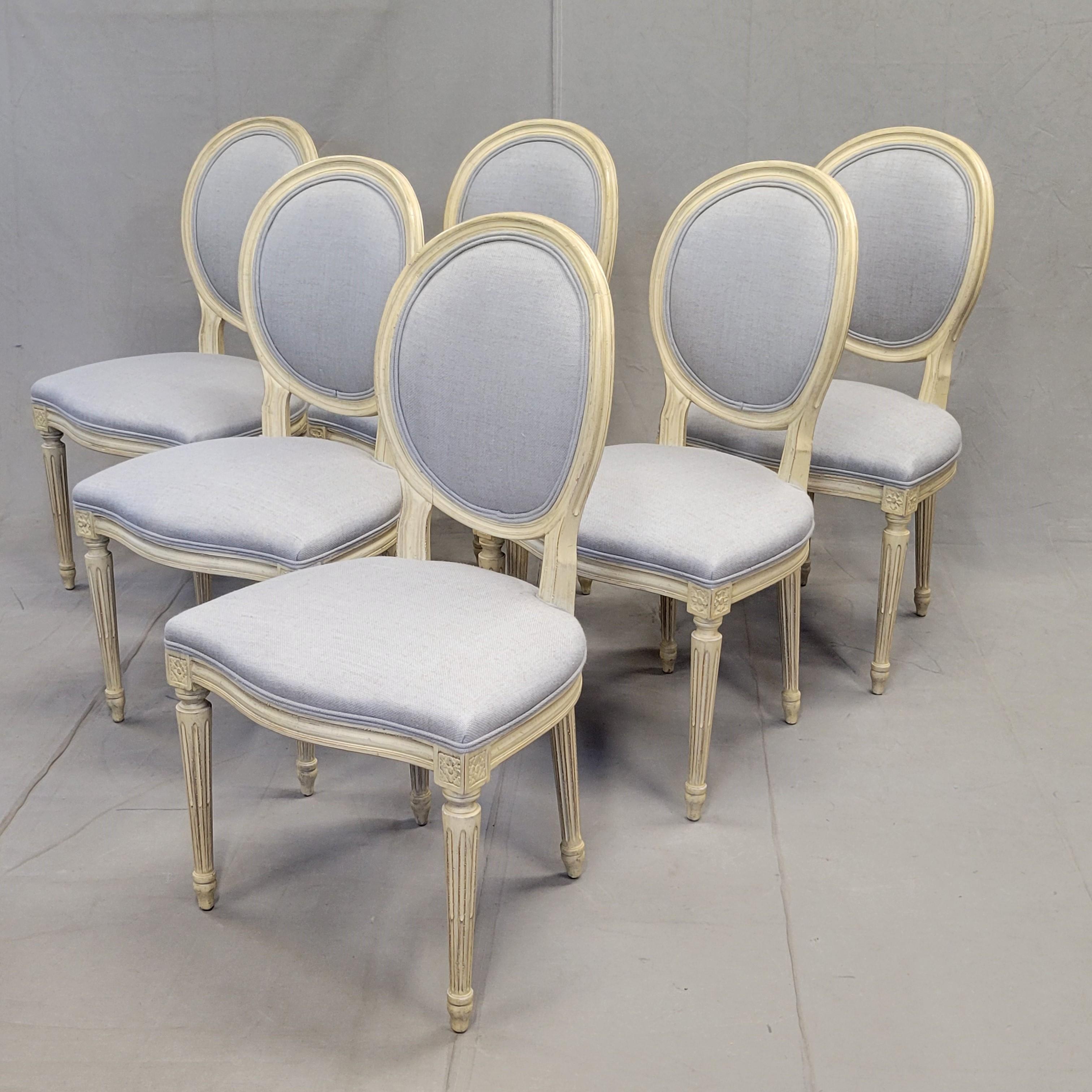 A beautiful set of vintage Baker Furniture French Louis XVI style dining side chairs that were recently reupholstered in a durable gray tweed fabric. The original finish is a distressed cream paint. Chairs are sturdy, strong and ready for many years