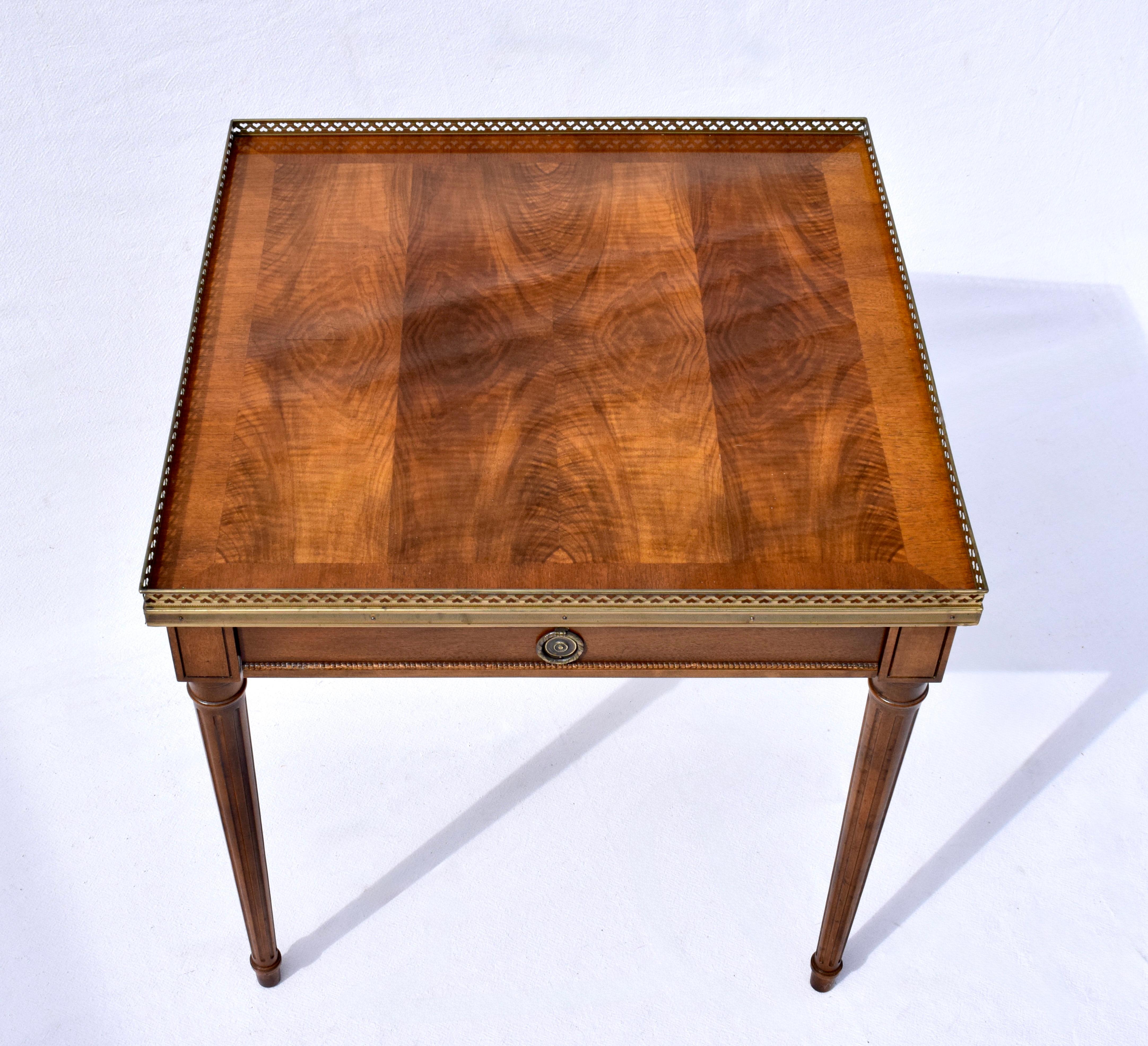 Table raffinée de style Louis XVI de Baker Furniture, délicieusement travaillée dans des grains de noyer assortis, un seul tiroir avec des pieds cannelés et effilés dans le style néoclassique.
Cette pièce intemporelle présente un plateau carré