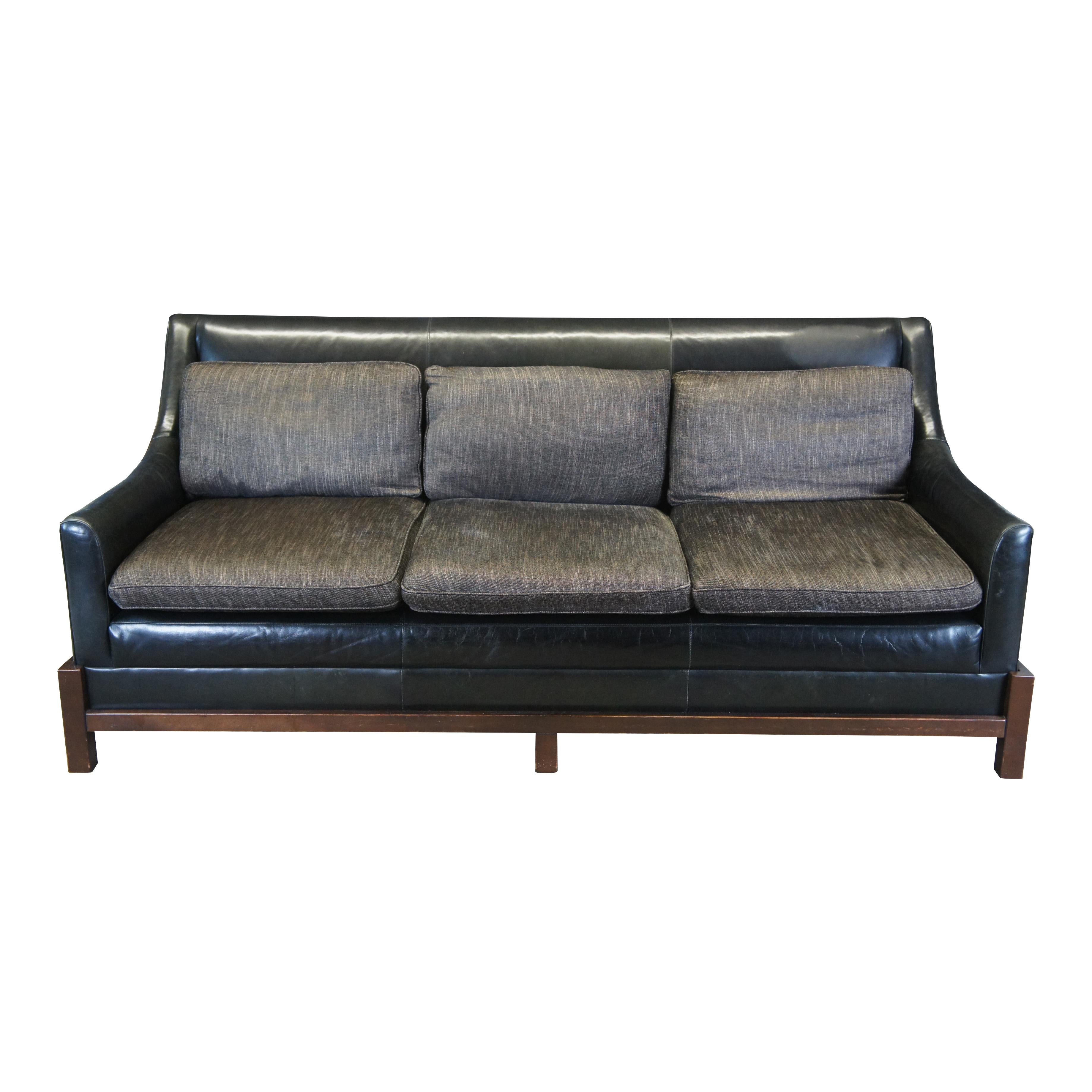 Laura Kirar for Baker Furniture Neue Sofa. Features a black leather frame with swoop arms on an espresso cradle. A three seat design with gray seat cushions and back rests. An elegant design that lends well in any modern setting.