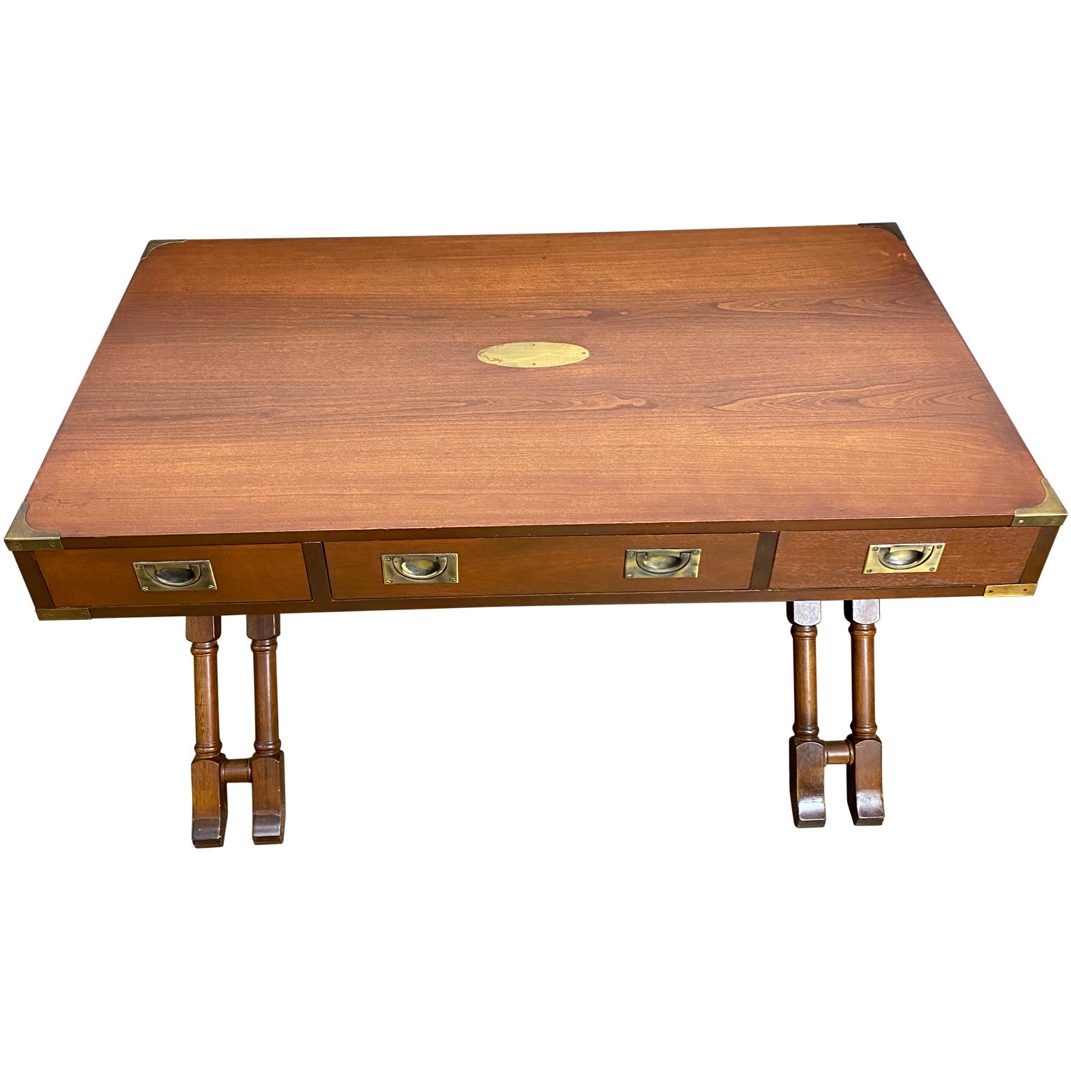 Vintage Campaign desk on X-base by Baker Furniture. The brass military handles are stunning and embedded into the drawers as well as brass edge and side decorative handles. The X-base has turned wood detailing. Mahogany wood is in very good