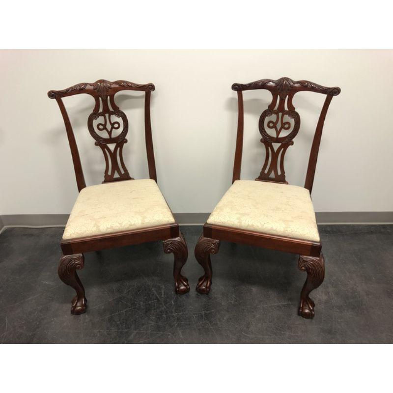 A pair of dining side chairs by Baker Furniture Company. Made in the USA in the late 20th Century. Solid Mahogany. Chippendale carved backsplats, cabriole legs with carved knees and ball in claw feet. Distressed finish.

Measures: Overall: 24 W 25 D