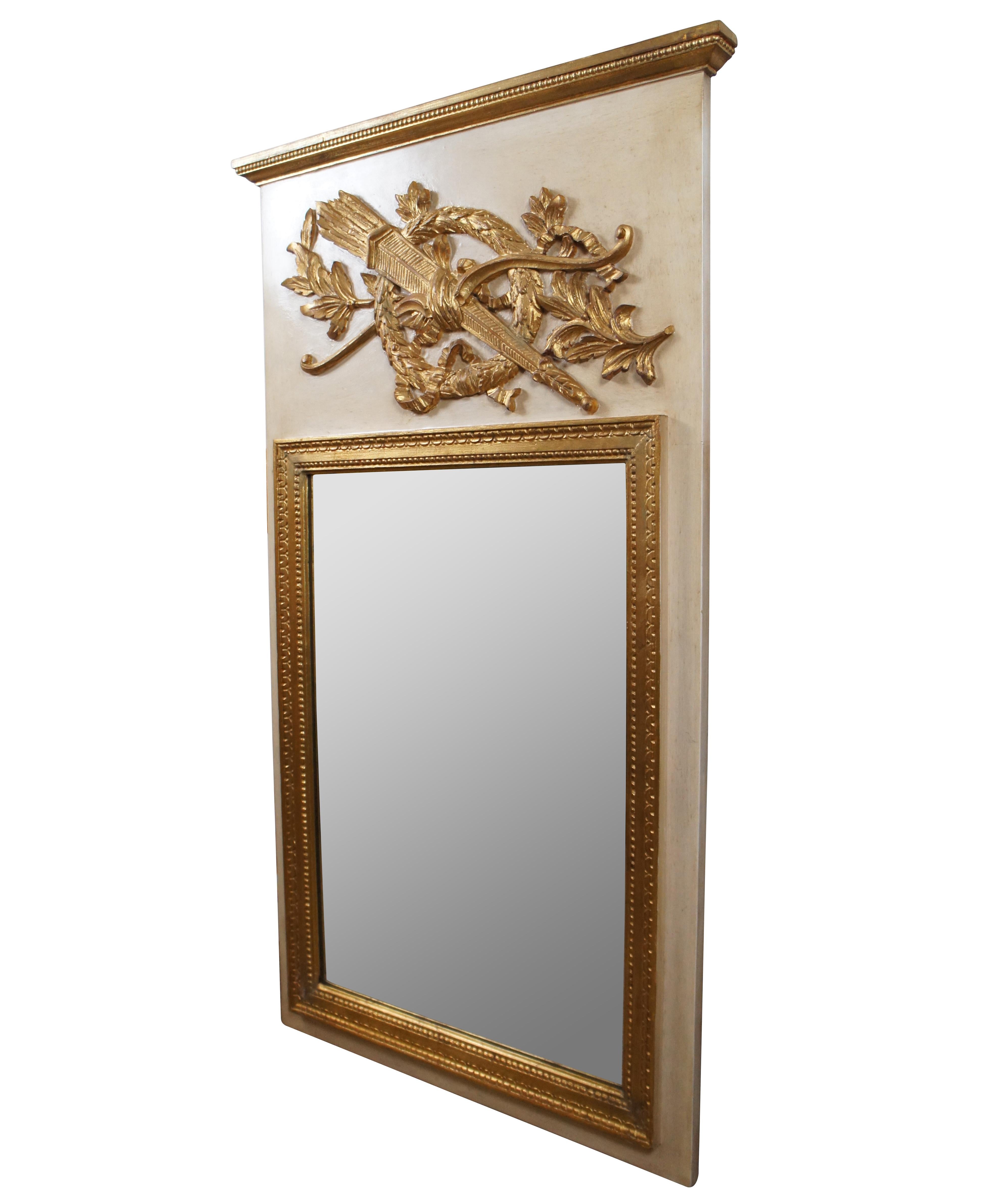 Late 20th century Baker Furniture number 3033 Louis XVI style trumeau mirror, made in Italy with a hardwood frame, painted in cream with giltwood mirror frame, pediment and medallion in the shape of a bow and quiver of arrows interlocked with a