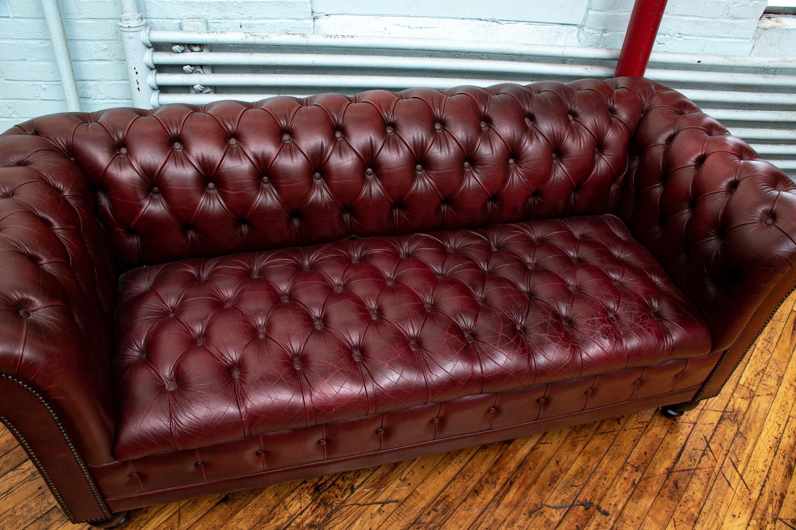 With nailhead trim and raised on turned feet. In a nicely worn patina with expected wear but good condition.