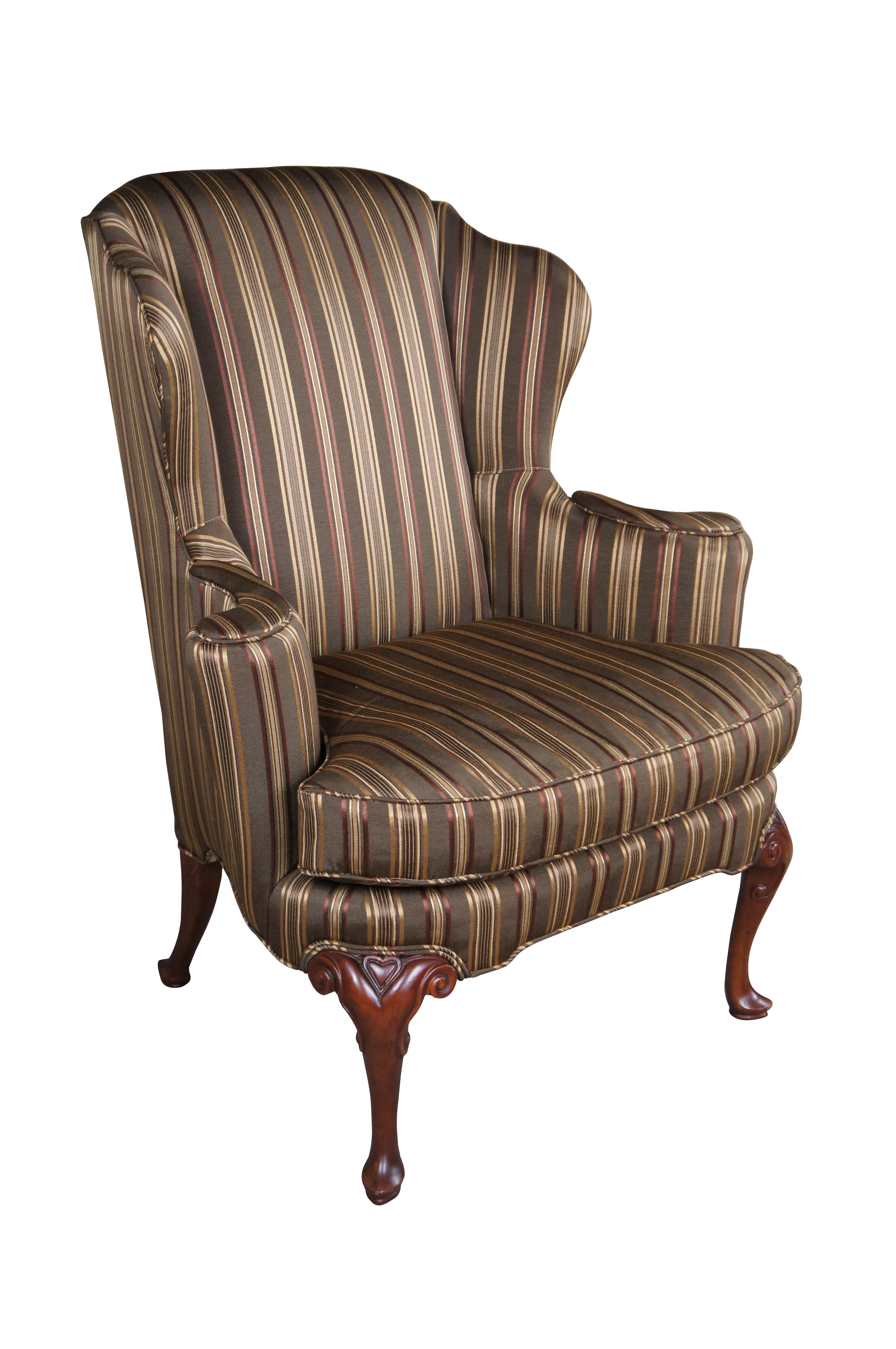 Un majestuoso sillón con respaldo de Baker Furniture, de hacia la década de 1980.  Presenta una postura abierta y acampanada tapizada en un bonito tejido de seda a rayas.  La silla se apoya en perfectas patas cabriolé talladas por encima de la