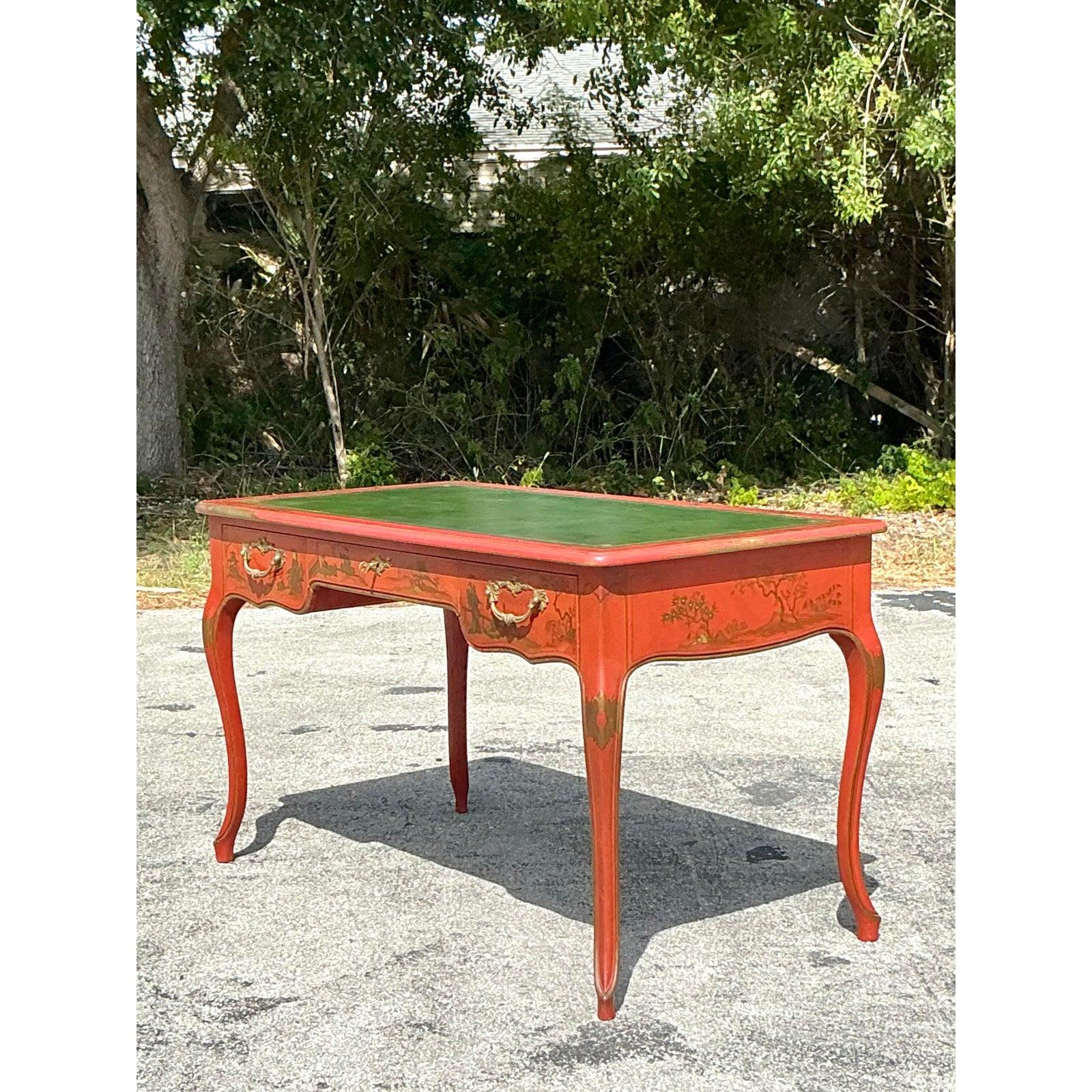 Entdecken Sie die Faszination dieses rot lackierten Chinoiserie-Schreibtisches von Vintage Baker, der zeitlose Eleganz und außergewöhnliche Handwerkskunst verkörpert. Dieser Schreibtisch der geschätzten Baker Furniture Co. besticht durch eine satte