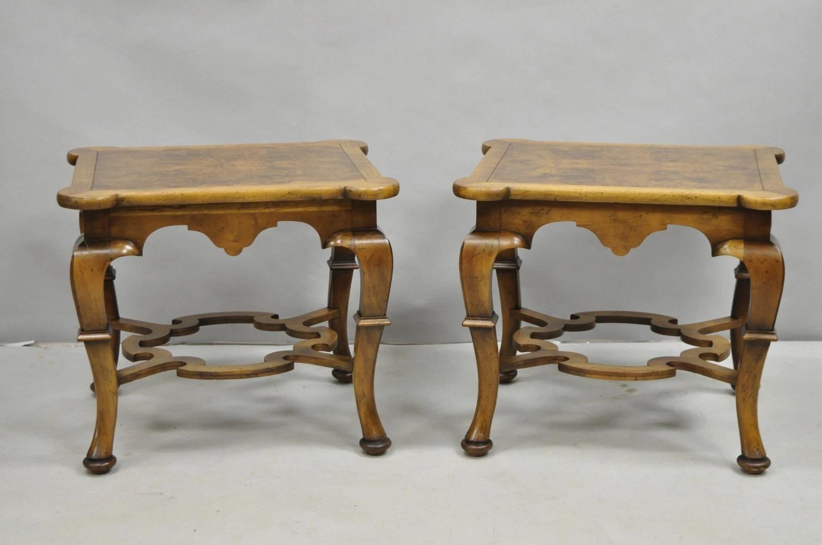 Vintage Baker Regency Style Burlwood Walnut Low Side End Tables with Carved Stretcher Base - a Pair. Item features a shaped top, shapely legs, distressed finish, and original labels. Circa Mid 20th Century. Measurements: 18