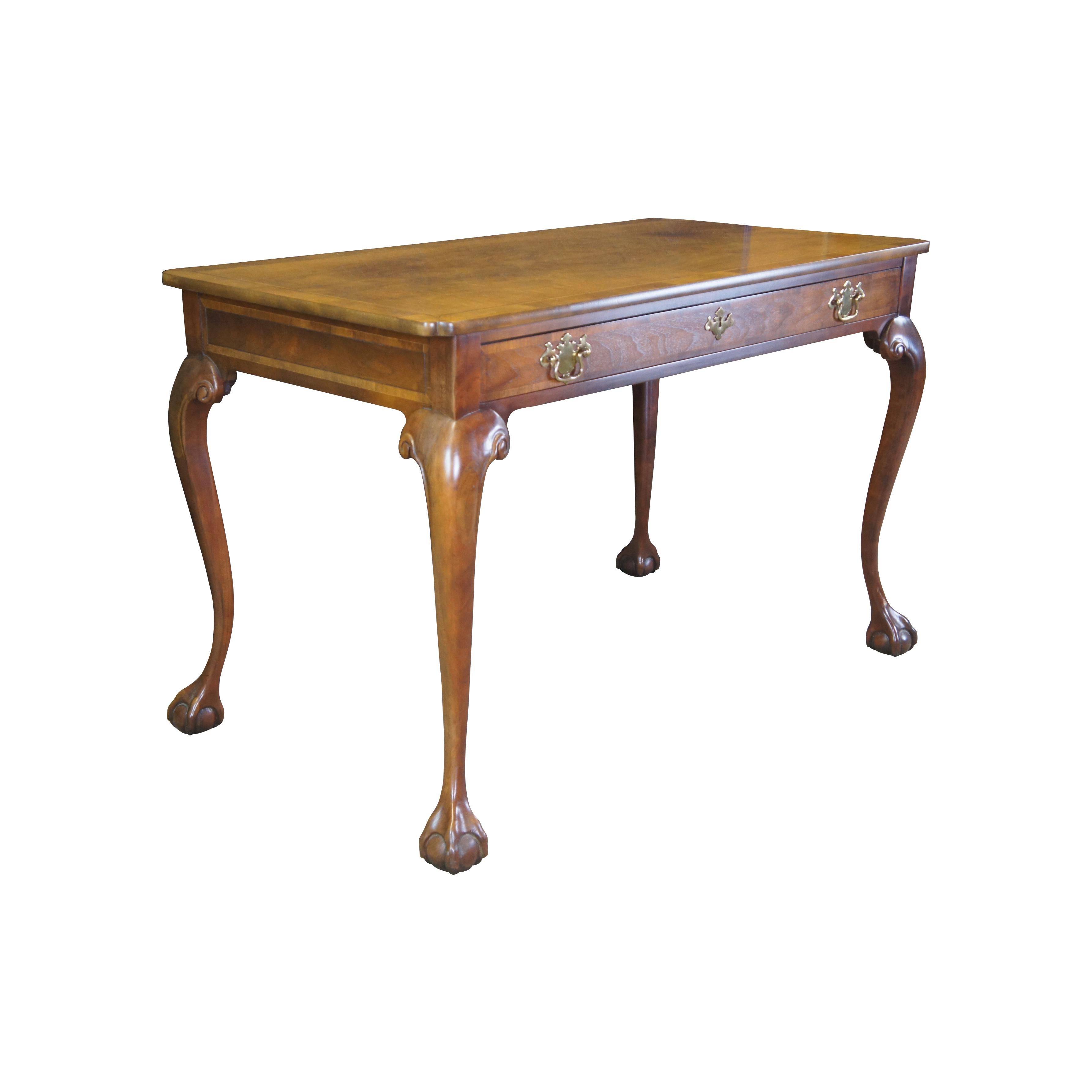 20th century Baker Stately Homes English Georgian Chippendale Style Writing Desk. A rectangular form made from walnut with a beautiful matchbook top. The desk features herringbone inlay throughout, a large dovetailed drawer with key and long