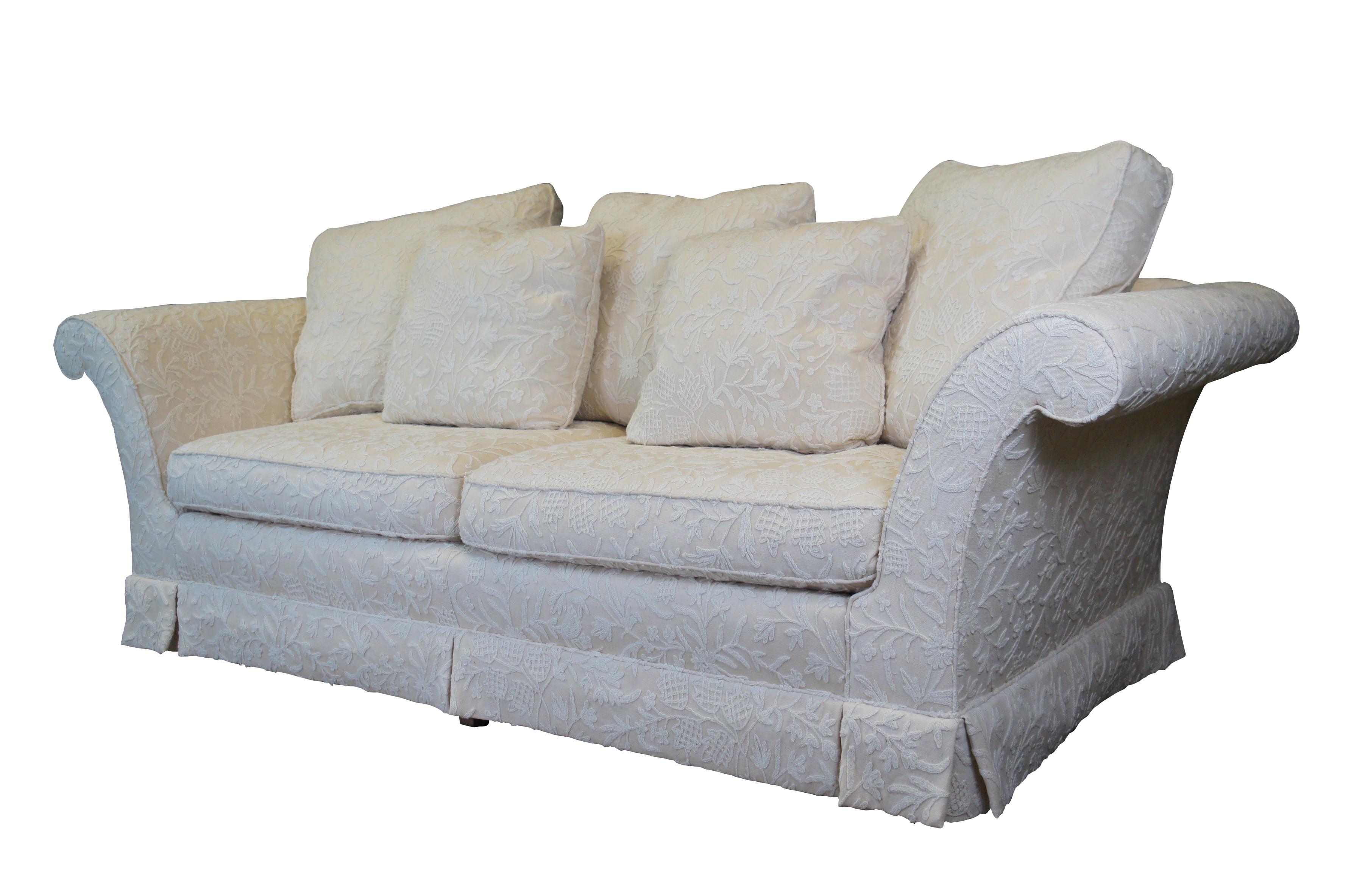 Baker Furniture George IV Skirted Sofa by Stately Homes, 886-86, circa 1990s.  A traditional form upholstered in ivory wool fabric with flared rolled arms and a straight back with slight contoured shoulders.  The sofa is supported by square tapered