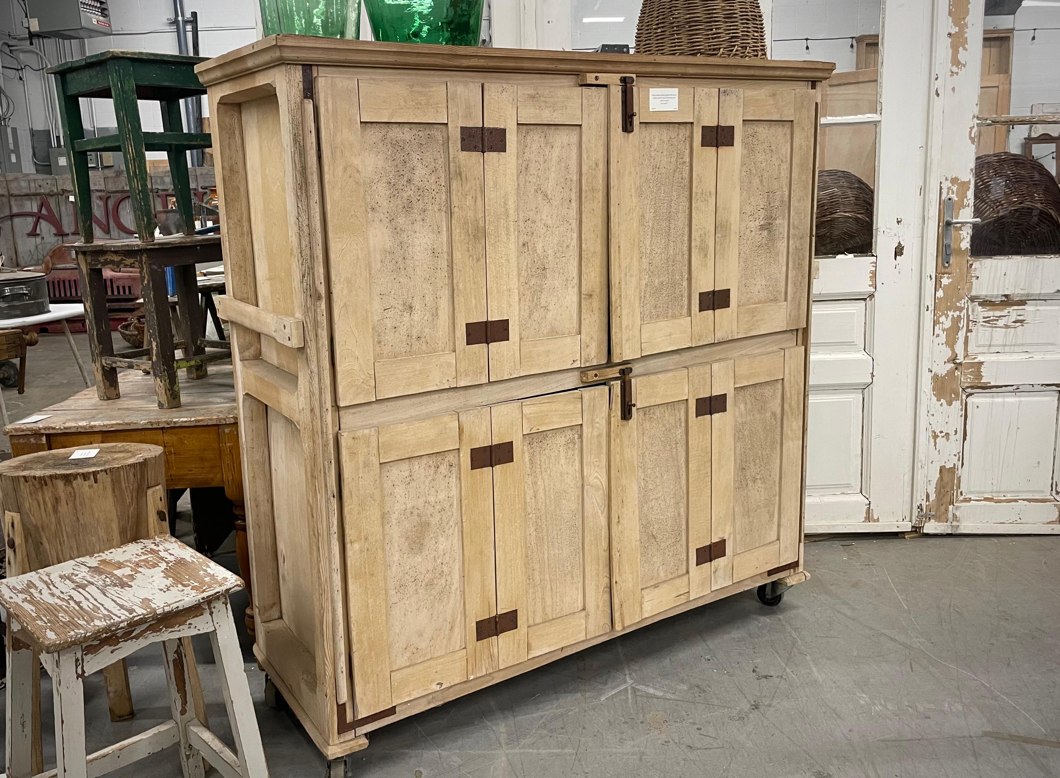 Vintage baker’s cupboard with pull out drawers, behind 4 sets of bi-fold doors, and raised on casters. 

It was once used for the proofing dough in a French bakery! Today it can be utilized as a useful kitchen storage cupboard. 