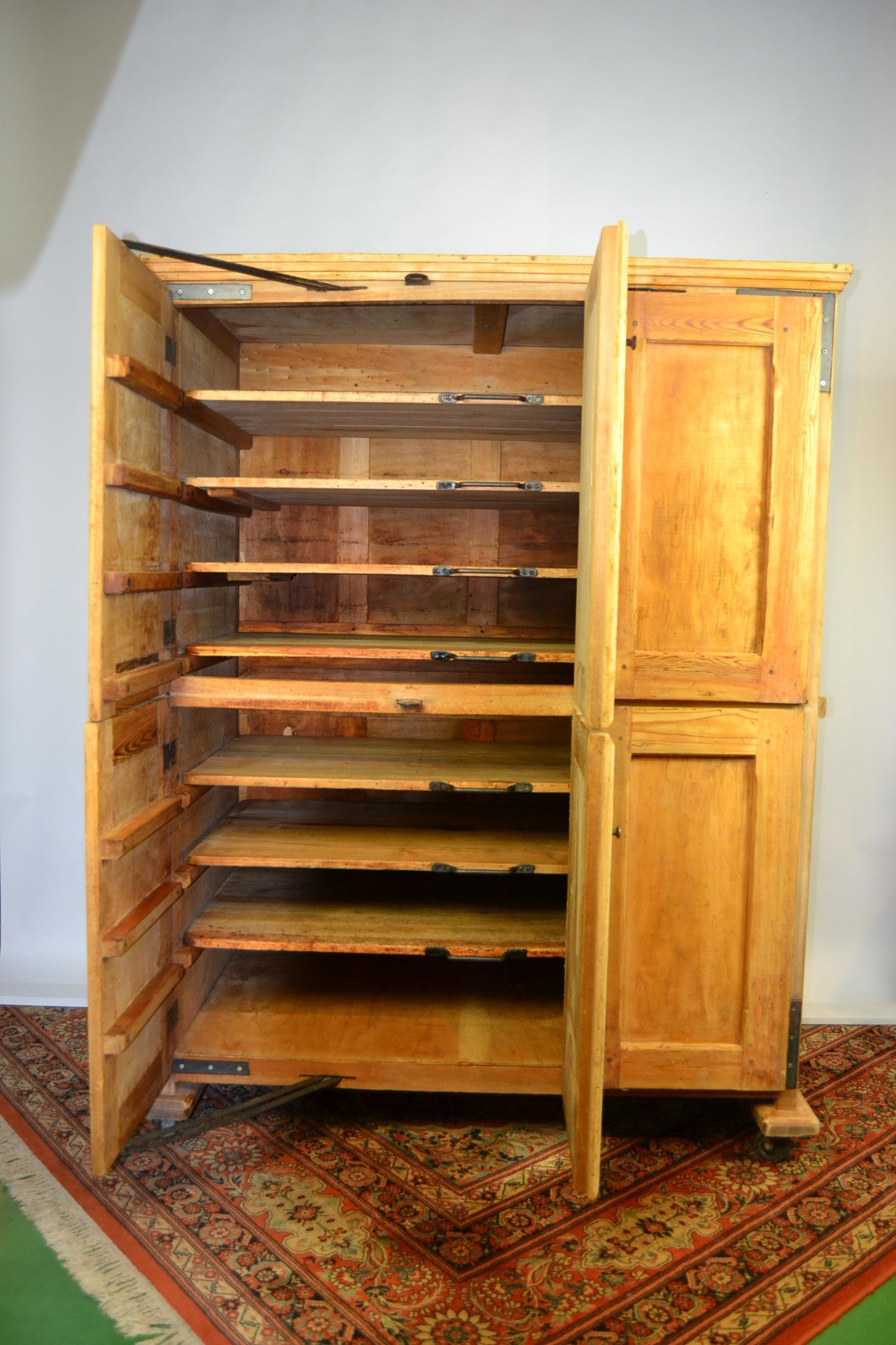 Awesome wooden vintage Bakery Cabinet on wheels.
This Baker's Cabinet was made by  Ets. Walravens - Dekoninck Brussels Belgium circa 1940. 
Original Company Sign is still on.
This type of Baker's cabinet was used to let the dough yeast and rest to