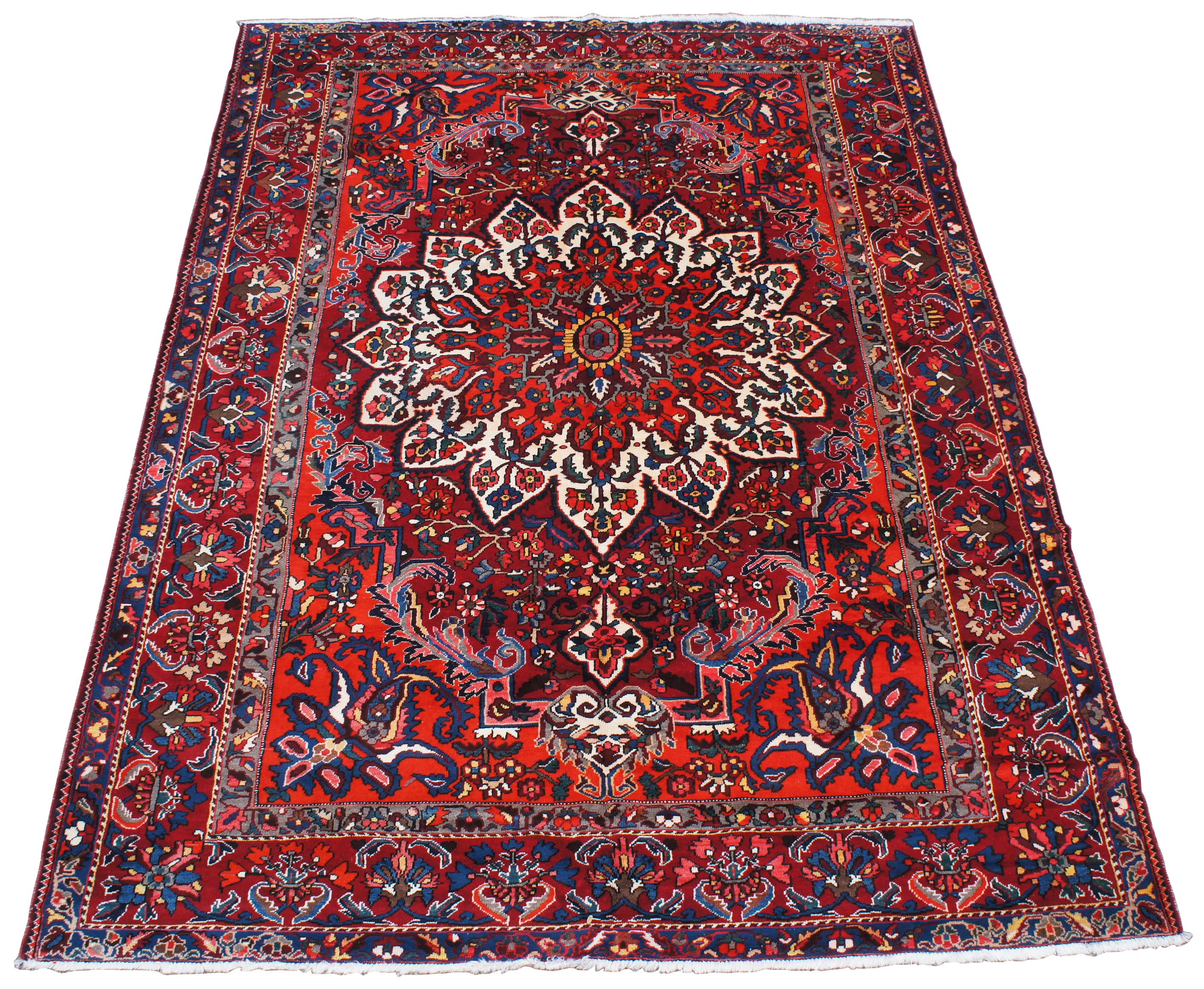 Vintage Bakhtiar Isfahan Oriental rug. Features a floral all-over design with central starburst or sunburst medallion over a field of reds with white / cream / tan, blues, greens, pinks, yellow, grey, brown, orange and black accents. Made in Central