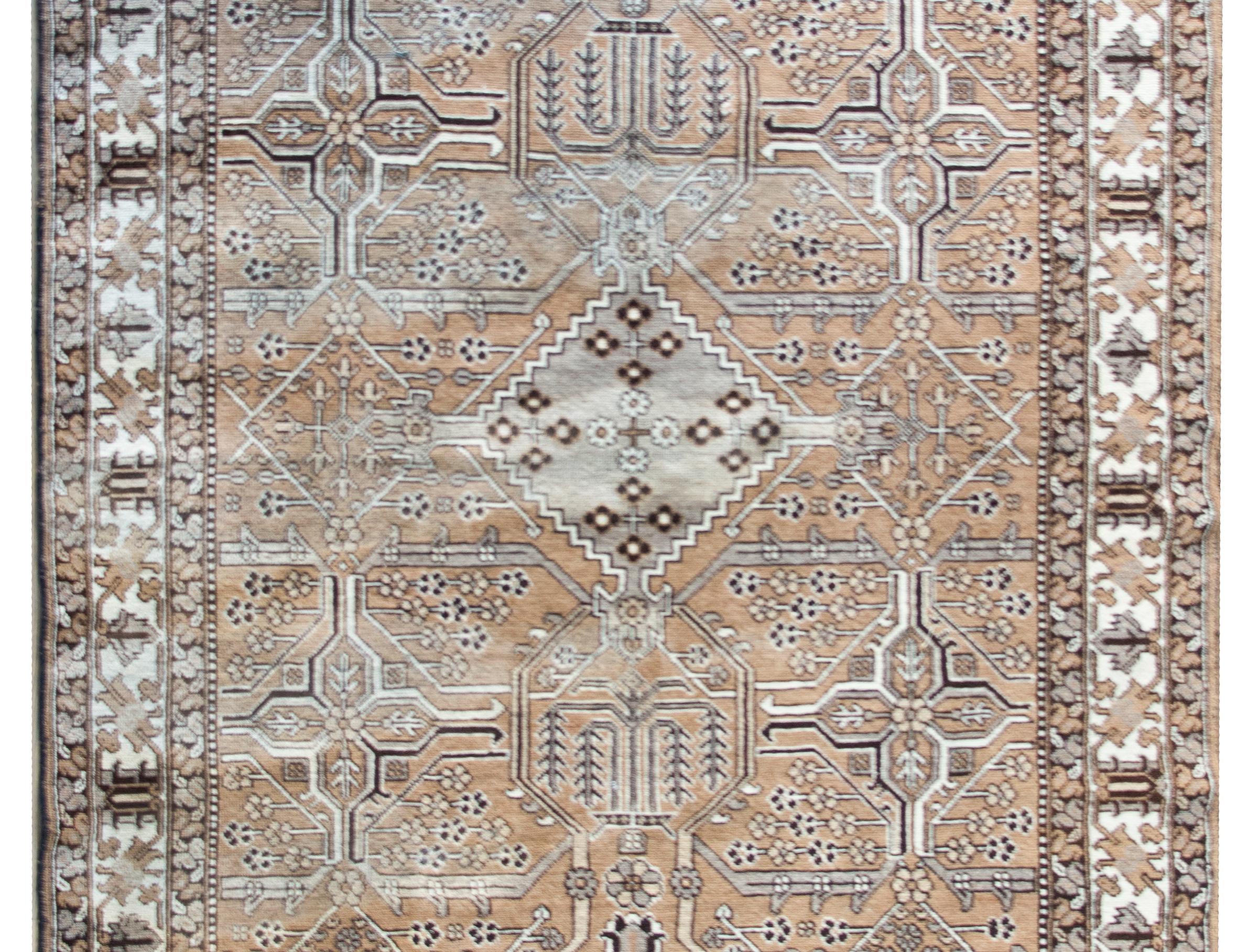 A wonderful vintage Persian Bakhtiari rug with a wonderful geometric patchwork pattern of myriad flowers and vines arranged in a trellis pattern, surrounded by a wide border with a large-scale floral and leaf pattern flanked by a matching pair of