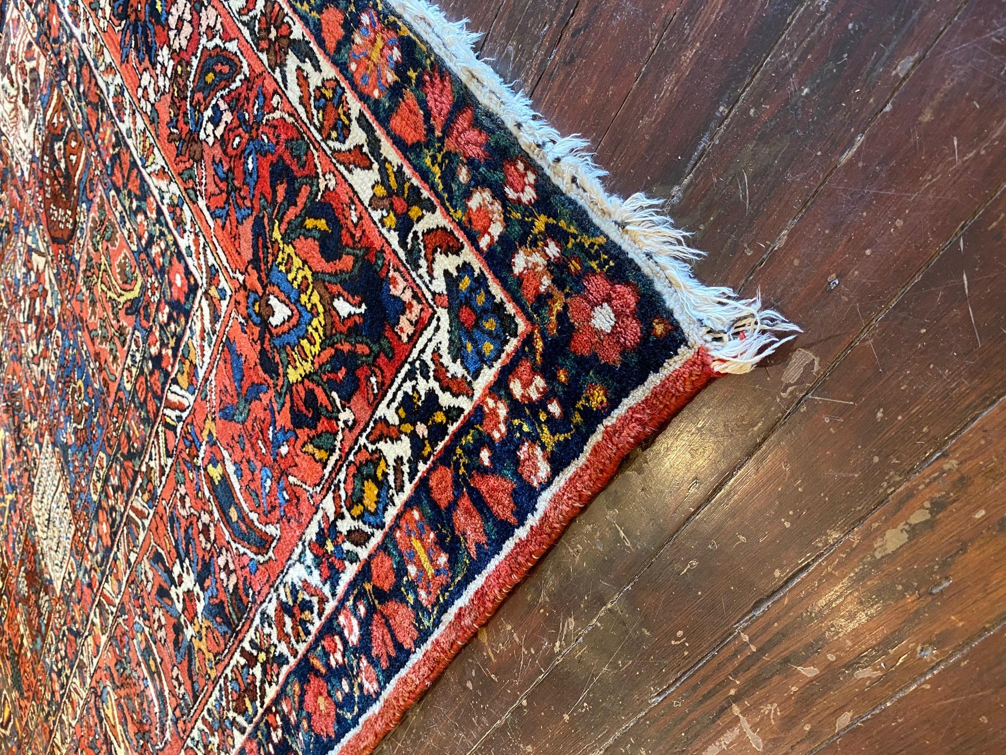 Experience the enchanting beauty of the Early Twentieth Century Persian Bakhtiyar Rug, a true treasure crafted with 100% wool. This exceptional rug mesmerizes with its rich and vibrant colors, including deep reds, blues, brass, green, and gold. The