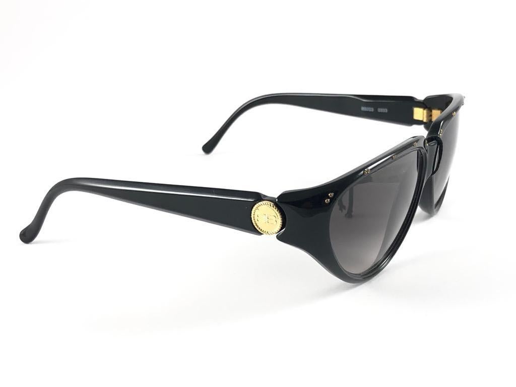 Vintage Balenciaga sleek black with gold accents frame holding a spotless pair of grey gradient lenses.

This pair could show minor sign of wear due to storage.

Designed and produced in France.

Front : 15 cms
Lens Height 4  cms
Lens Width 6 cms 