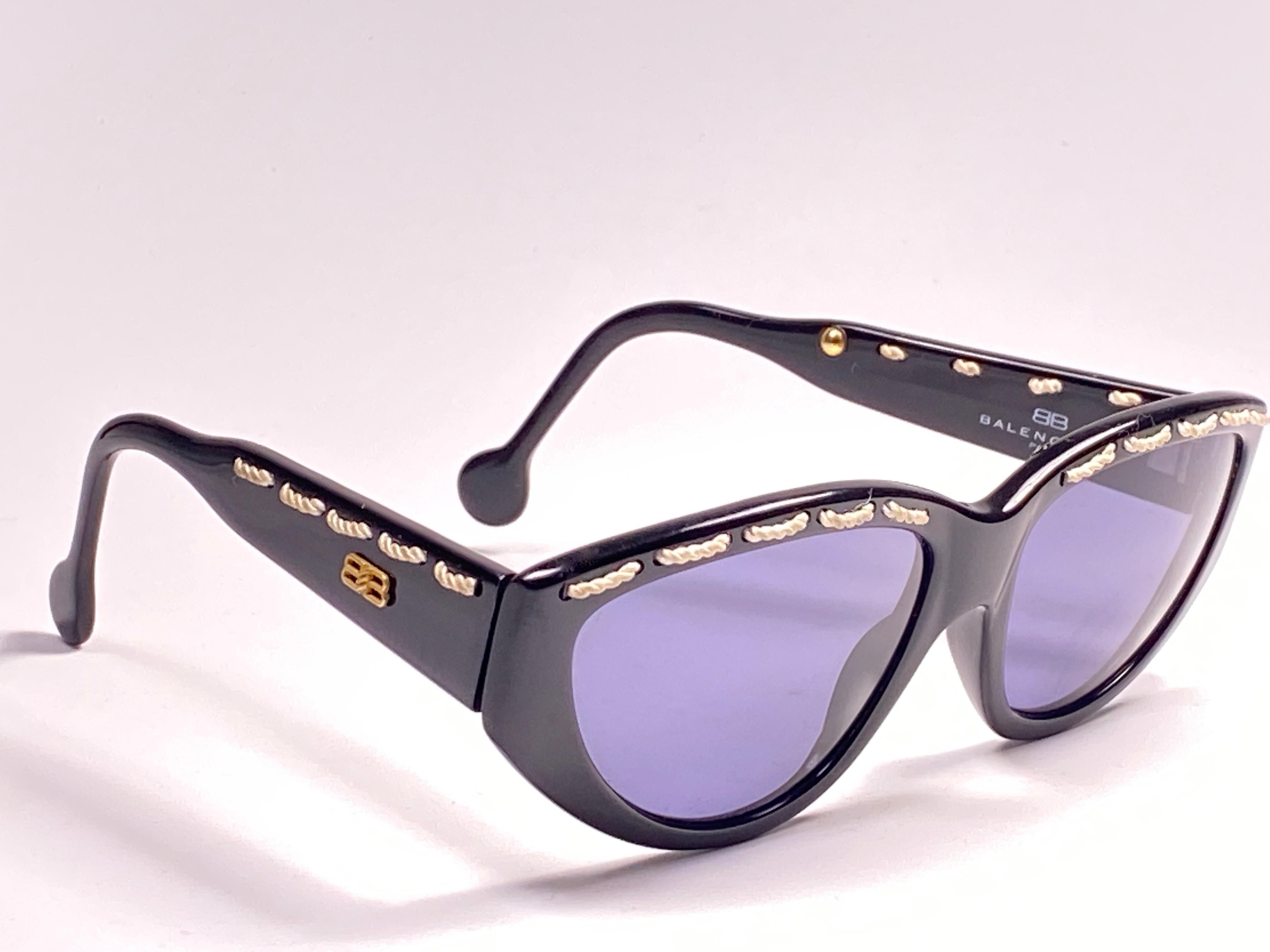 Vintage Balenciaga sleek black with white rope accents frame holding a spotless pair of grey lenses.

This pair could show minor sign of wear due to storage.

Designed and produced in France.
