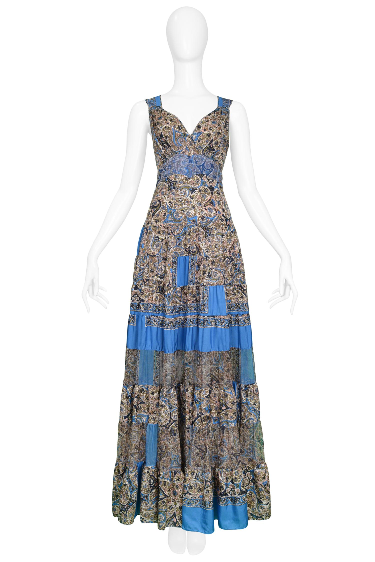 We are excited to offer a vintage Balenciaga by Nicolas Ghesquiere blue and paisley print bohemian maxi dress featuring patchwork panels, some sheer panels, a long full skirt, exposed neckline, and an attached sash that ties in the back. The dress