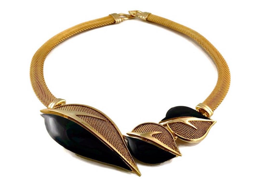 Vintage BALENCIAGA Enamel Leaves Mesh Choker Necklace

Measurements:
Height: 2 inches
Width: 4 5/8 inches
Wearable Length: 15 inches

Features:
- 100% Authentic BALENCIAGA.
- Dark blue enamel and mesh leaves motif.
- Mesh/ snake chain.
- Gold