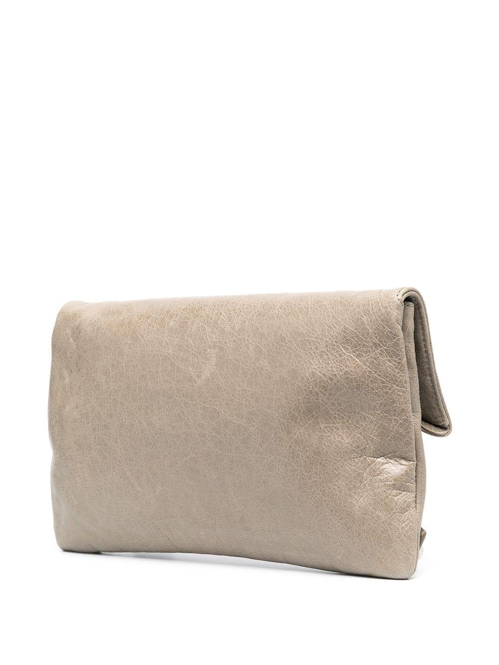 Exude the utilitarian sensibility of Demna Gvasalia's new Balenciaga with this vintage envelope clutch. In a shade of greige, its fold-over profile is accented with straps and silver-tone studs for a contemporary appeal. It opens with a magnetic