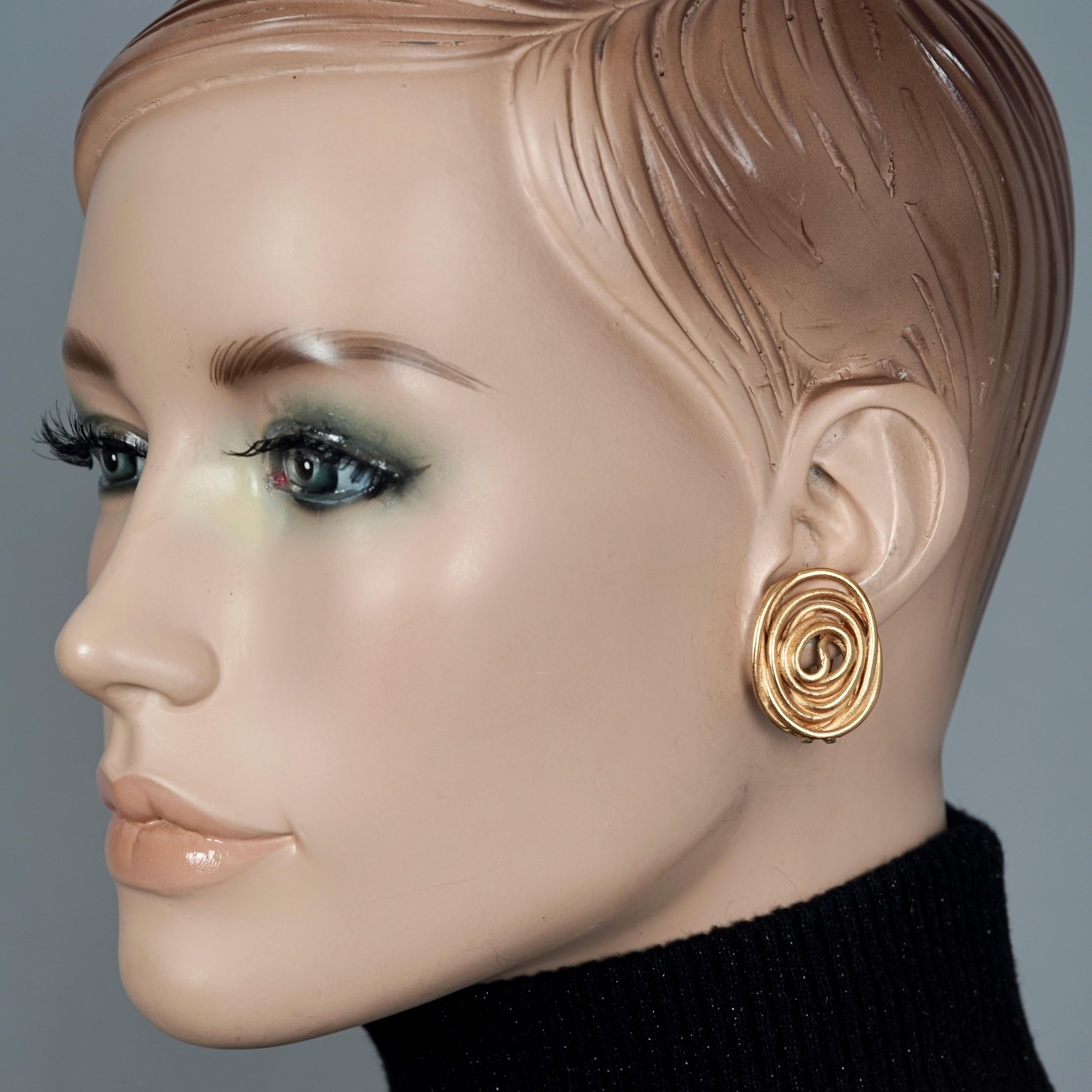 Vintage BALENCIAGA Spiral Earrings

Measurements:
Height: 1.14 inches (2.9 cm)
Width: 0.86 inch (2.2 cm)
Weight per Earring: 7 grams

Features:
- 100% Authentic BALENCIAGA.
- Oval wire spiral pattern.
- Gold tone hardware.
- Clip back earrings.
-