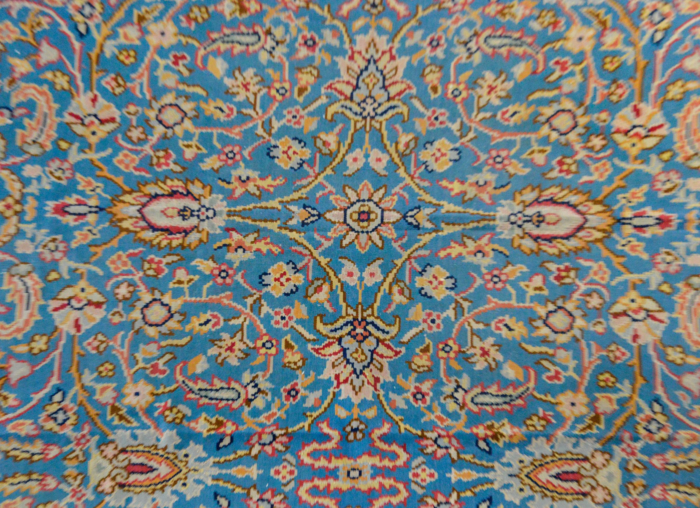 Ein süßer alter Balkhan-Kelim-Teppich mit einem gespiegelten Blumenmuster in Pastellrosa, Gelb, Blau und Orange auf hellblauem Hintergrund. Die Bordüre ist breit und mit mehreren großflächigen, floralen Partnerstreifen versehen.
