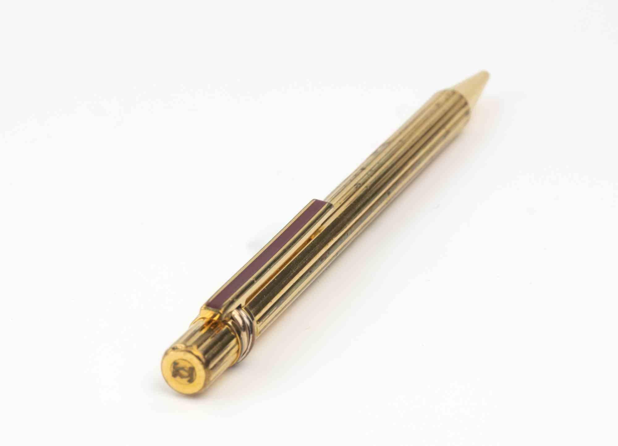 Bolígrafo Le Must de Cartier Vendome.

Cuerpo y capuchón estriados y chapados en oro; al presionar la parte superior del capuchón, el clip se abre a la anchura deseada; al soltar la presión, el clip vuelve a su posición original.

Número de edición