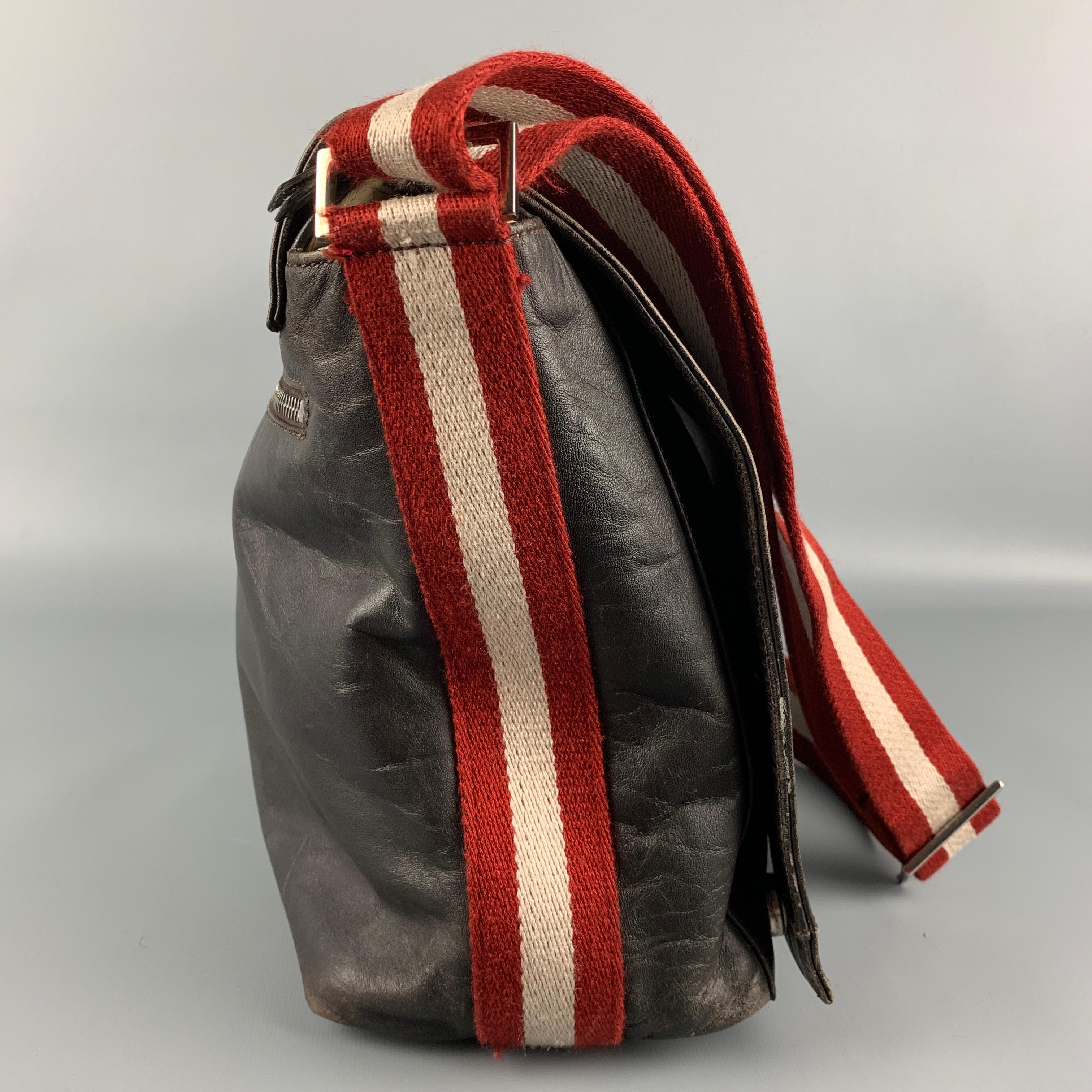 Vintage BALLY bag comes in a brown leather featuring a messenger style, woven shoulder strap, back pocket, front flap, inner compartments, and a zip up closure. 

Good Pre-Owned Condition.
Marked: TADELLA AABD

Measurements:

Length: 12 in.
Width: